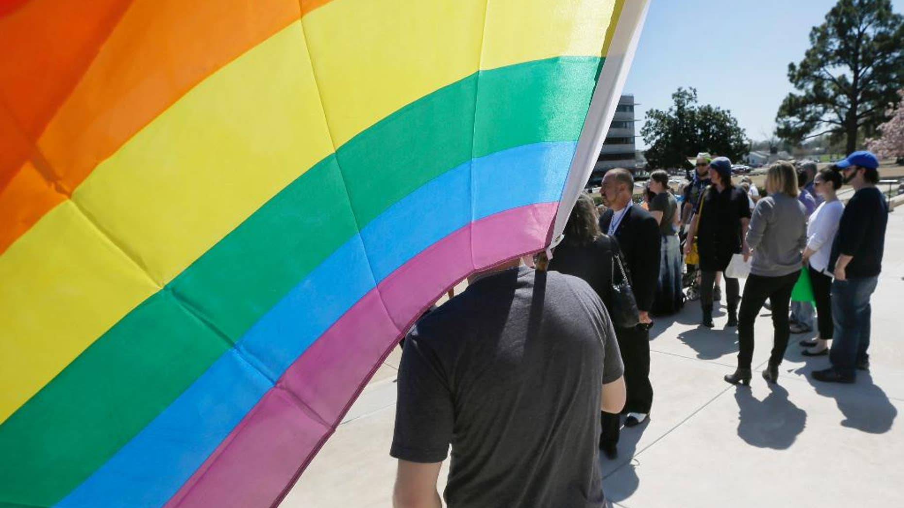 In this photo taken March 30, 2015, gay rights advocates gather at the Arkansas state Capitol in Little Rock, Ark. Arkansas Gov. Asa Hutchinson said Thursday, April 9, 2015, he doesn't see an urgent need for an executive order extending anti-discrimination workplace protections to gay and lesbian state employees after lawmakers approved a reworked religious objections bill. (AP Photo/Danny Johnston)