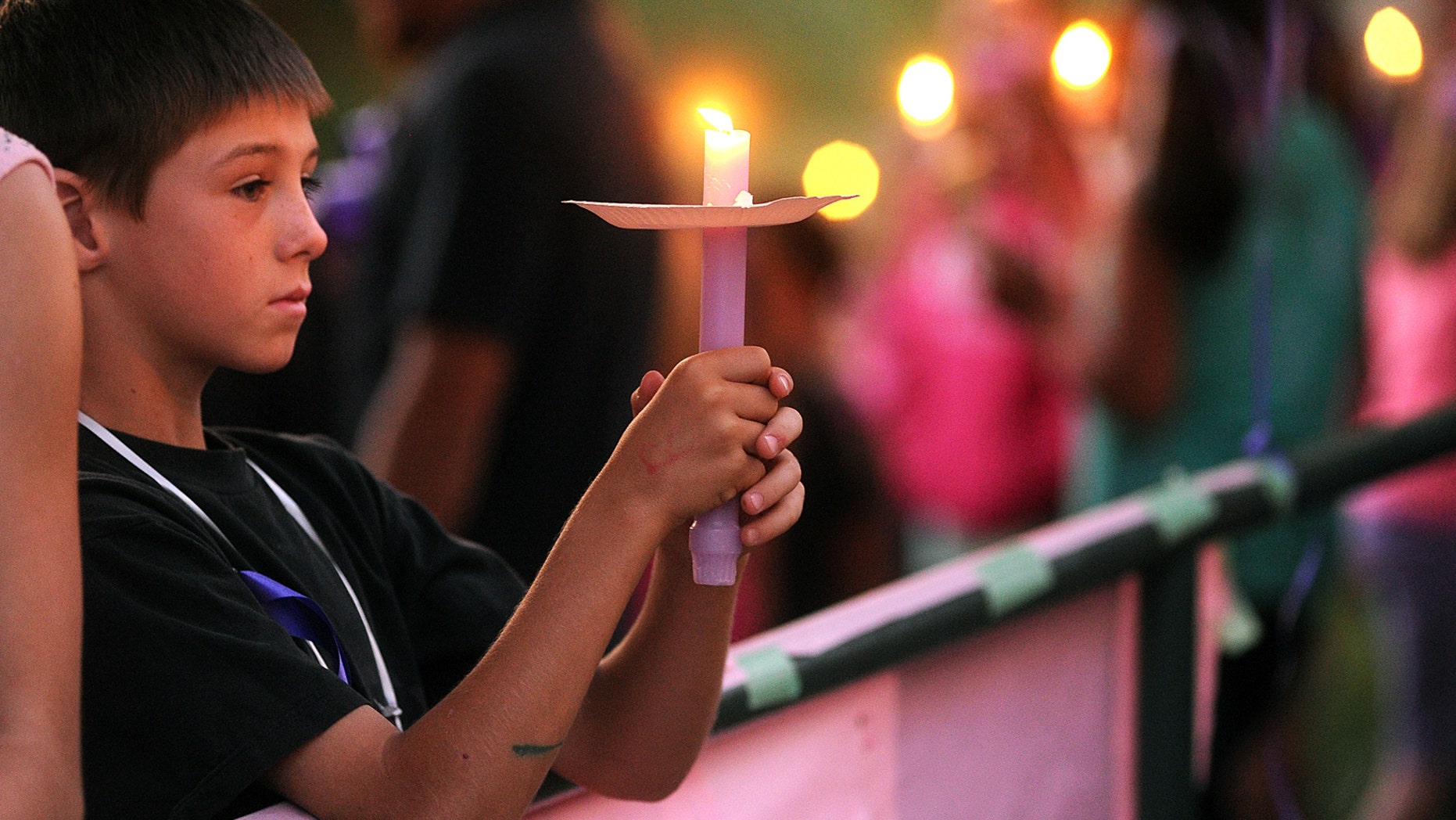 In this Tuesday, April 30, 2013, photo, student Elliott Berry, 8, attends a memorial vigil for slain 8-year-old girl Leila Fowler at Jenny Lind Elementary School in Valley Springs, Calif. (AP Photo/The Modesto Bee, Elias Funez)