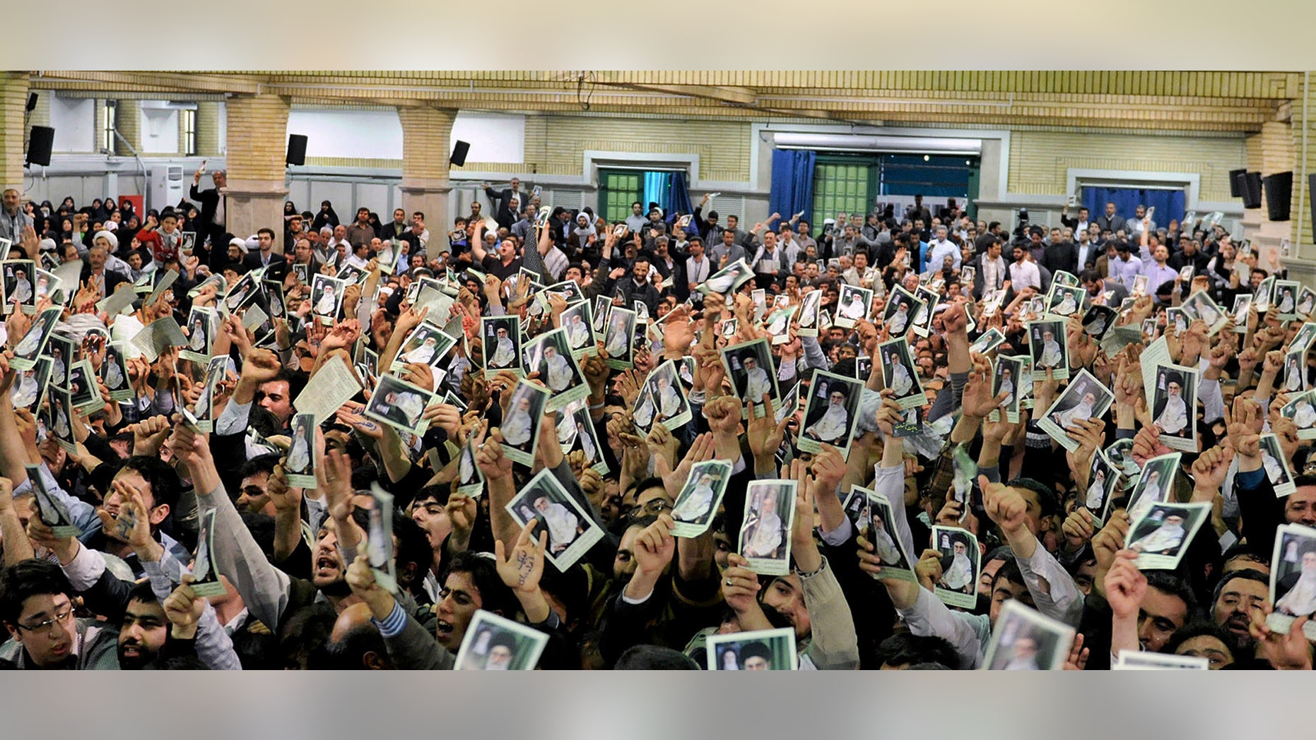 In this photo released by the official website of the Iranian supreme leader's office, Iranian well wishers attending the speech of Supreme Leader Ayatollah Ali Khamenei hold up his picture at a mosque inside the leader's housing compound in Tehran, Iran, Saturday, Feb. 16, 2013. Khamenei said Saturday that his country is not seeking nuclear weapons, but that no world power could stop Tehran's access to an atomic bomb if it intended to build one. (AP Photo/Office of the Supreme Leader)