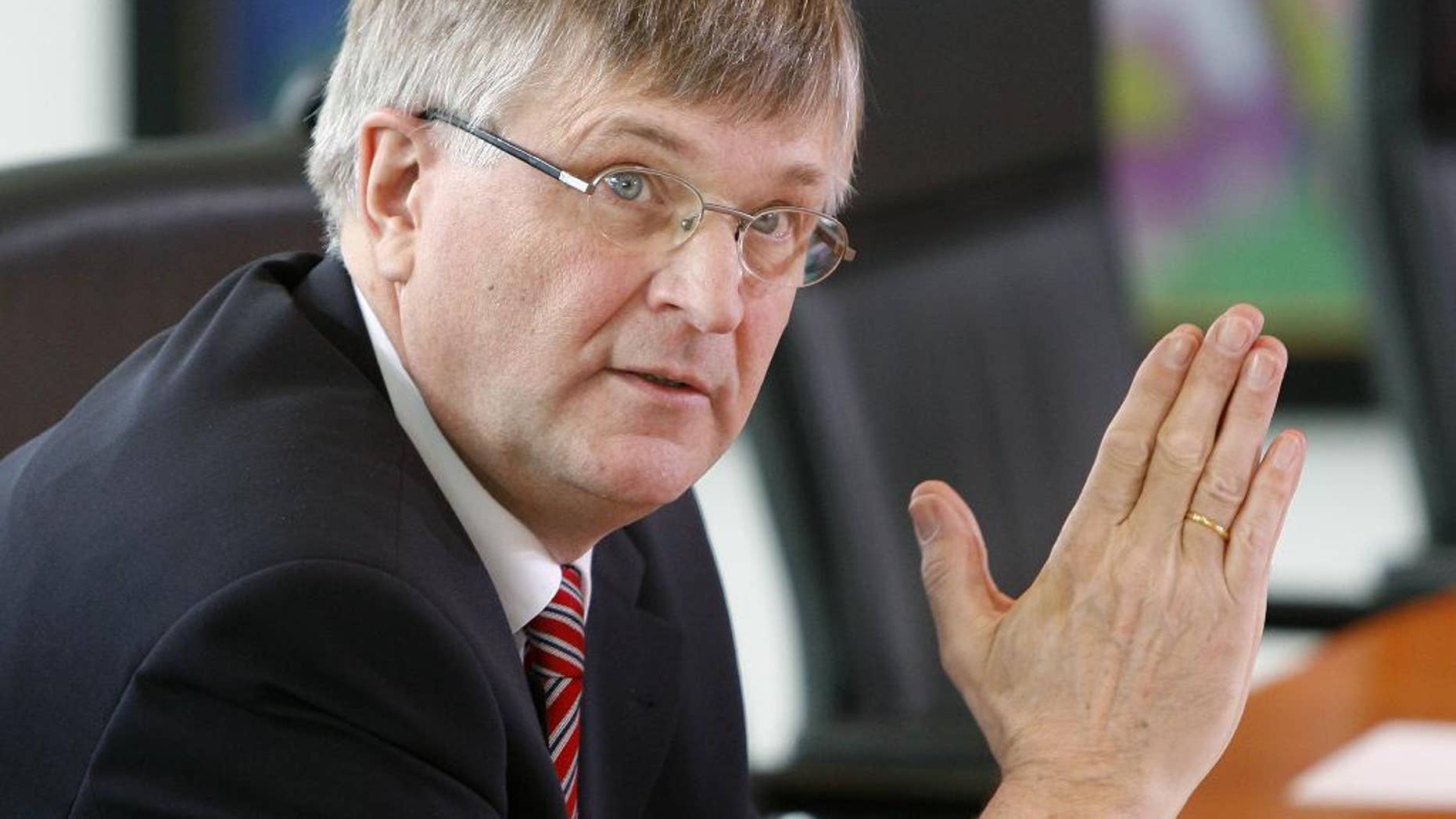 FILE - In this April 16, 2008 file picture Peter Hintze, then Parliamentary Secretary to the German Federal Ministry of Economy, holds his hands folded at the beginning of a cabinet meeting at the chancellery in Berlin, Germany. Chancellor Angela Merkel’s party says Sunday Nov. 27, 2016, Peter Hintze, a deputy speaker of Parliament who was close to the German leader, has died. He was 66. (AP Photo/Michael Sohn,file)