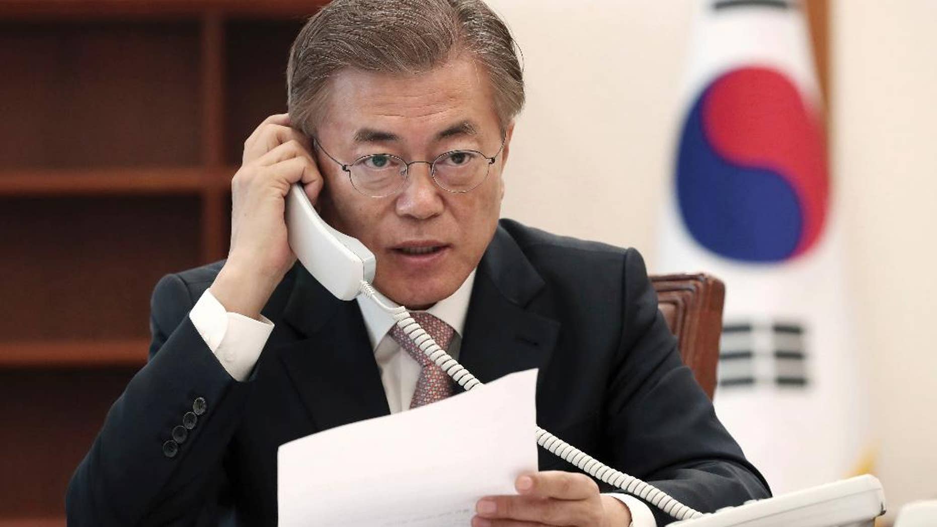 South Korean President Moon Jae-in talks on the phone with Chinese President Xi Jinping at the presidential Blue House in Seoul, South Korea, Thursday, May 11, 2017. Moon told his Chinese counterpart that he plans to send a special delegation to Beijing for talks on North Korea and a contentious U.S. missile-defense shield, Seoul officials said Thursday. (Yonhap via AP)
