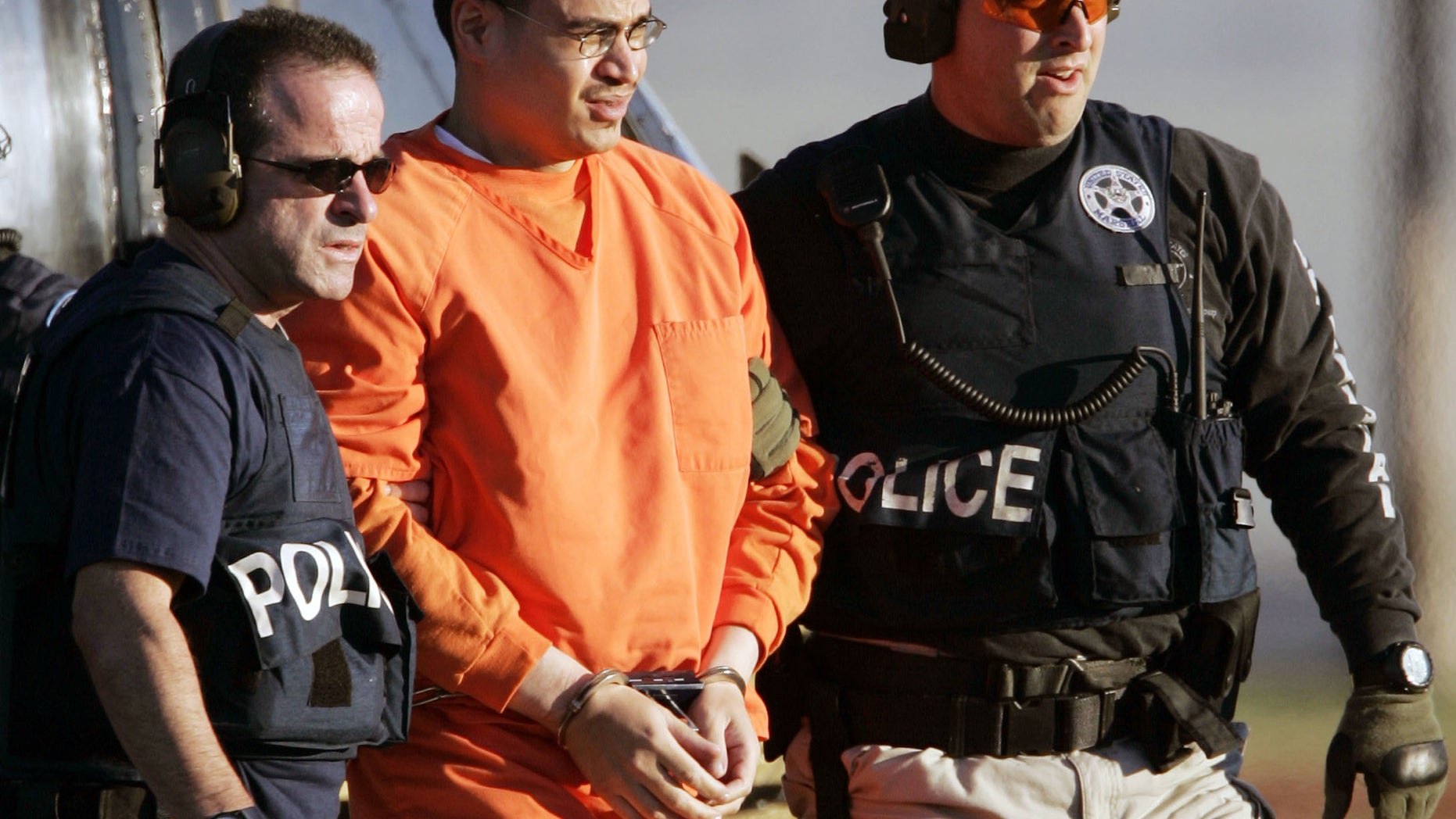 FILE - In this Jan. 5, 2006, file photo, Jose Padilla, center, is escorted by federal marshals on his arrival in Miami. Miami U.S. District Judge Marcia Cooke scheduled a Wednesday afternoon Feb. 12, 2014 hearing for Padilla. He originally was sentenced to 17 years of prison for terrorism support and conspiracy convictions. A federal appeals court ruled in 2011 that the sentence was too lenient, given Padilla's lengthy criminal record and terrorist training at an al-Qaida camp in Afghanistan.(AP Photo/Alan Diaz, File)