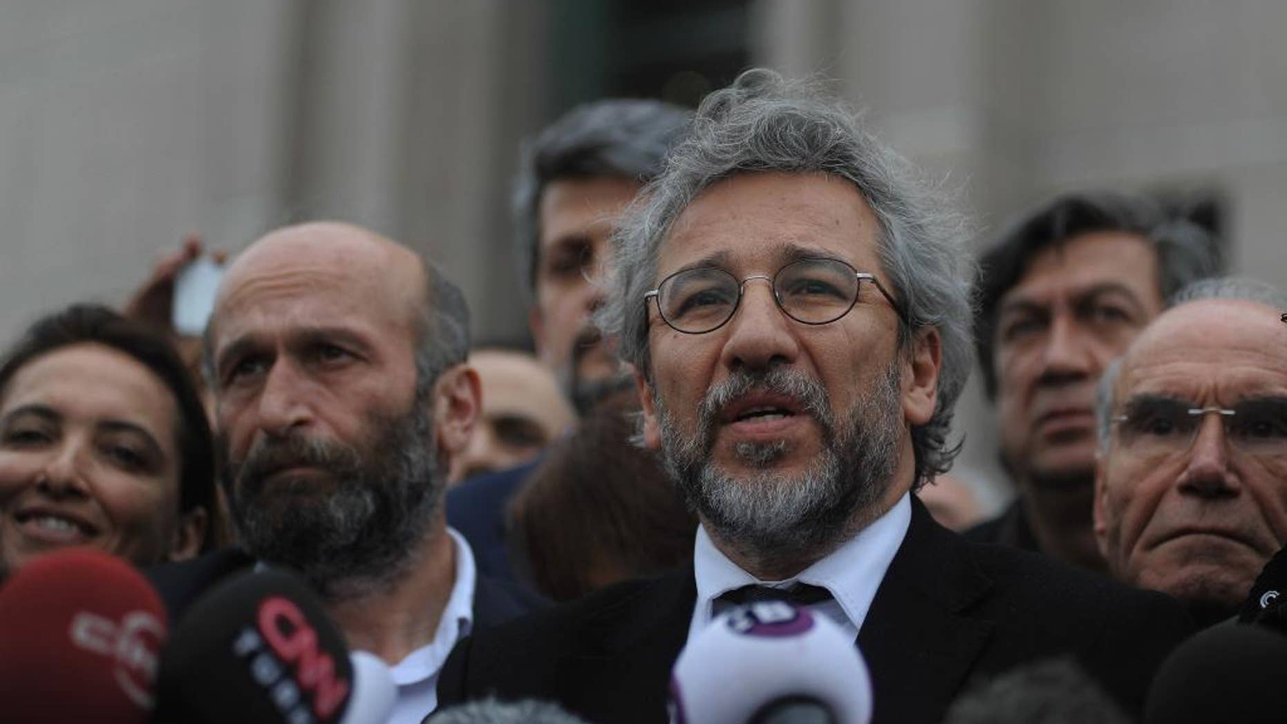 Can Dundar, the editor-in-chief of opposition newspaper Cumhuriyet, right, and Erdem Gul, left, the paper's Ankara representative, speak to the media after their trial in Istanbul, Friday, March 25, 2016. The trial of two Turkish journalists accused of revealing state secrets and helping a terrorism organization over their reports on alleged government-arms smuggling to Syrian rebels was adjourned on Friday after opposition lawmakers refused to leave the courthouse in defiance of a controversial ruling to proceed behind closed doors.(AP Photo/Omer Kuscu)