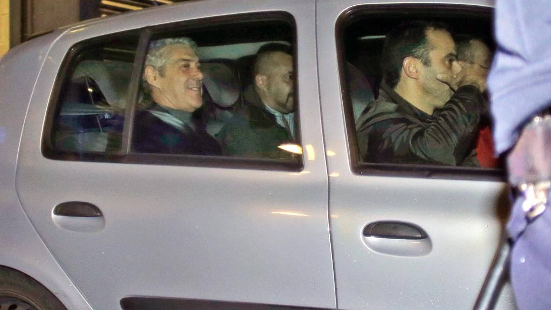 Portugal's former Prime Minister Jose Socrates, in the back seat of the car on the left, leaves a court in a Portuguese police car after being questioned, in Lisbon, Sunday, Nov. 23, 2014. Jose Socrates is spending a third straight night in jail as officials continue to investigate him for suspected corruption, money-laundering and tax fraud. (AP Photo/Francisco Seco)