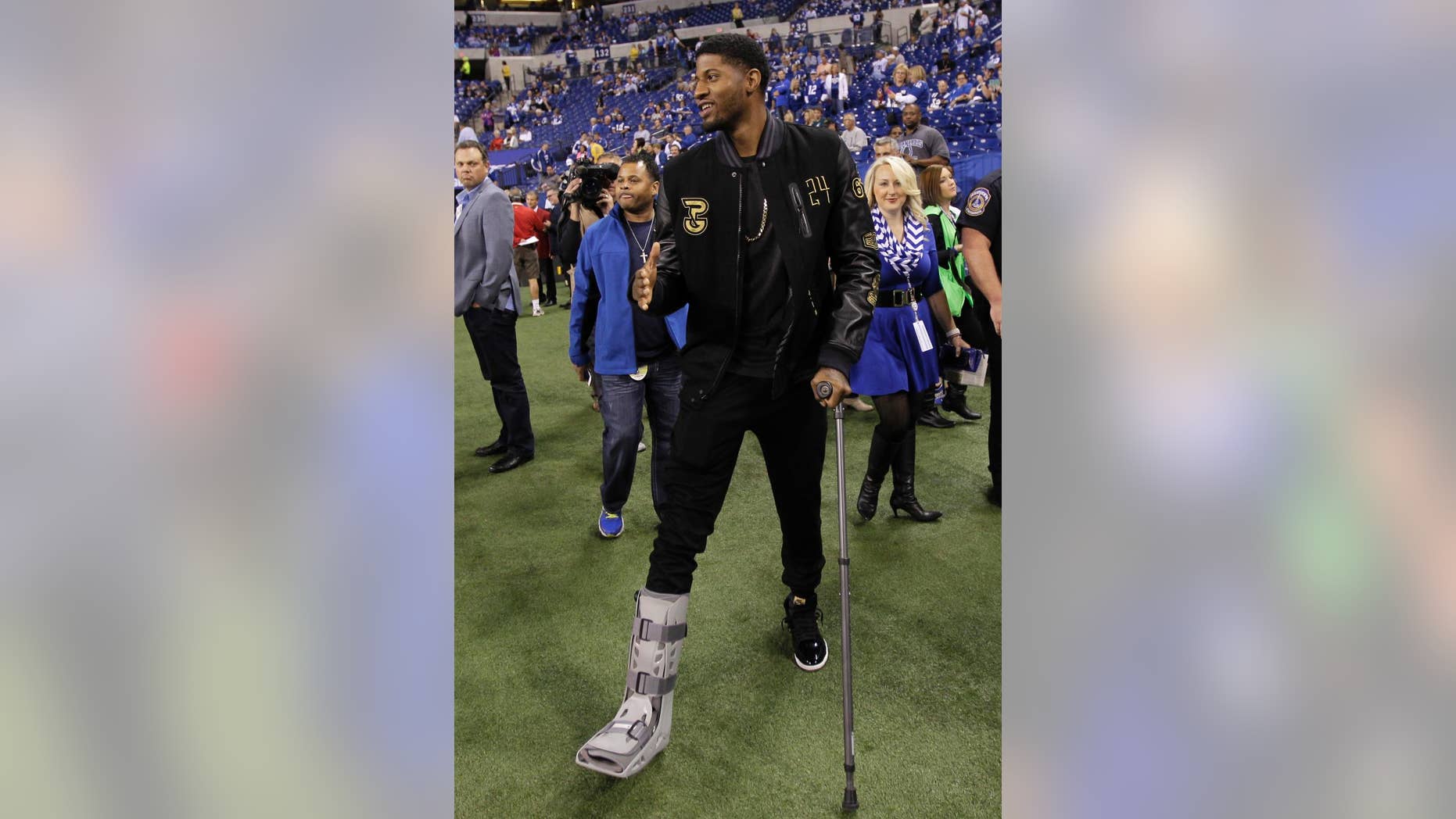 FILE - In this Sept. 15, 2014, file photo, Indiana Pacers' Paul George visits the sideline before the start of an NFL football game between the Indianapolis Colts and the Philadelphia Eagles in Indianapolis. Doctors have instructed Paul George to start putting weight on his broken right leg and have cleared him to do upper body weightlifting. Coach Frank Vogel provided the update Thursday, Sept. 25, 2014. (AP Photo/AJ Mast, File)
