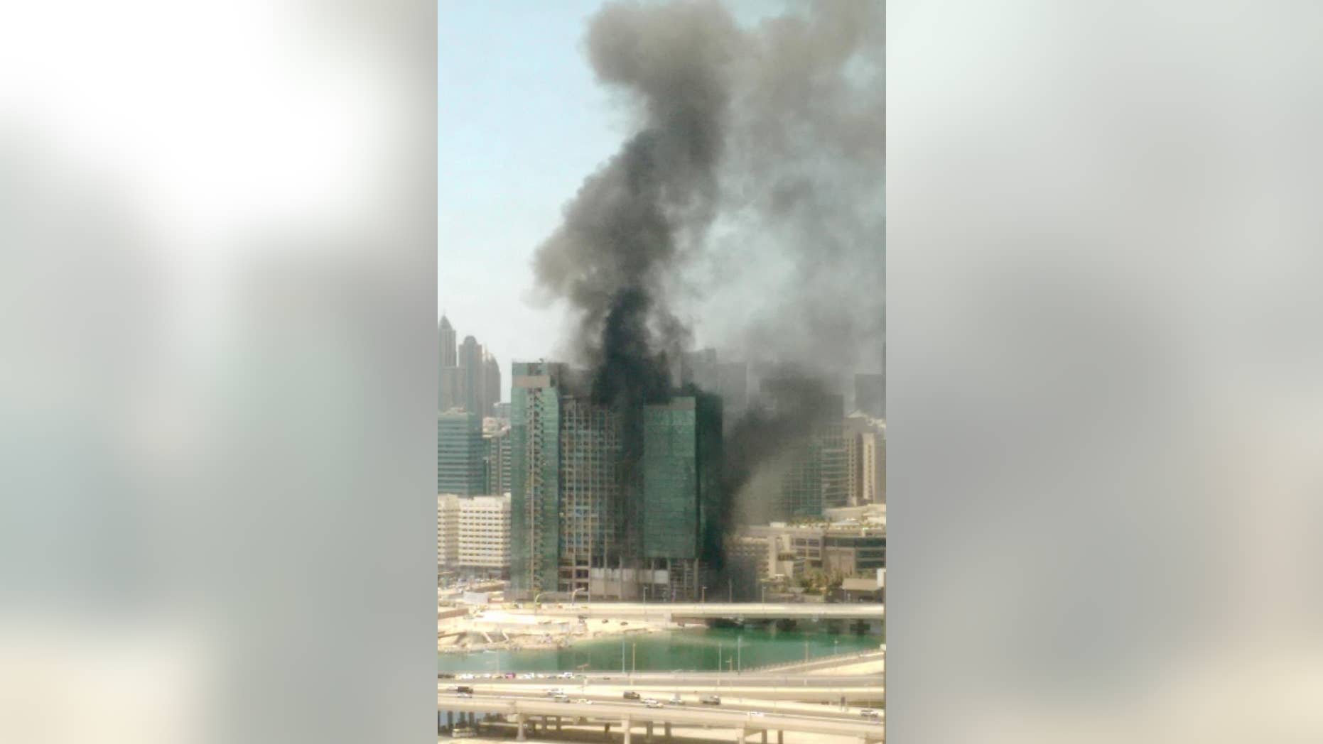 In this photo provided by Hasan Qureshi, smoke rises from a blaze that broke out in a high-rise building under construction in Abu Dhabi, United Arab Emirates, Tuesday, Aug 30, 2016. Cities in the fast-developing Emirates have been hit by a spate of fires in recent years, including one in a residential tower in Dubai last month and another at a luxury hotel next to the city's biggest shopping mall on New Year's Eve. (Hasan Qureshi via AP)