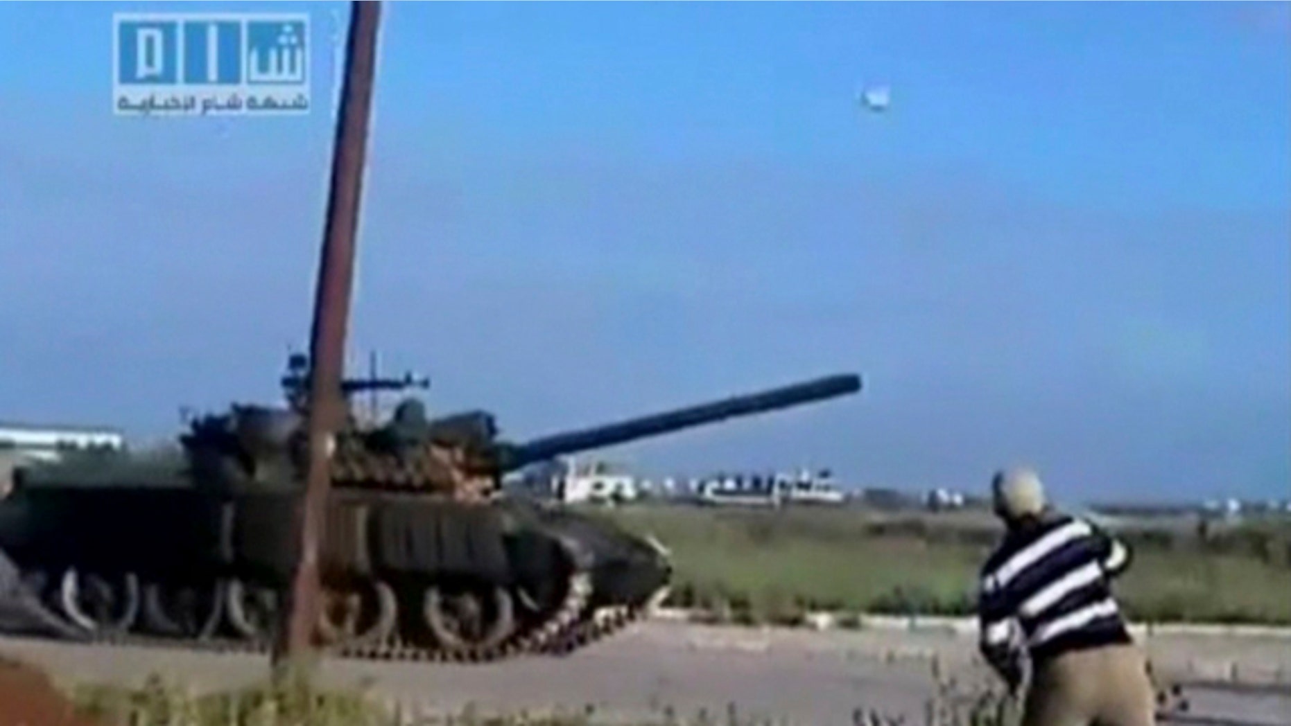 April 24: This video image taken from amateur video released by Sham News Network, a Syrian Freedom group, shows a man throwing an object at a tank in Daraa, Syria. (AP)