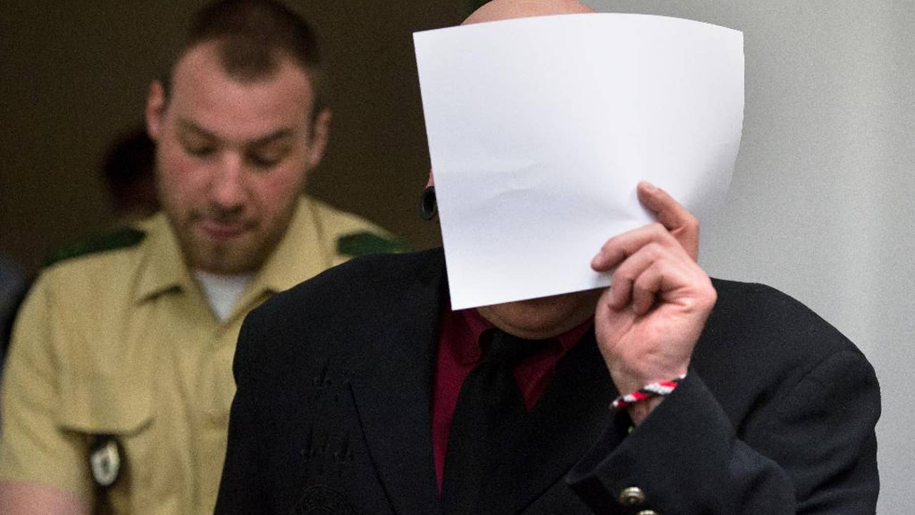 April 27, 2016: Member of the right-wing terror group Oldschool Society Markus W. (no second name given due to German law) covers his face as he is led into a courtroom in Munich, southern Germany. (The Associated Press)