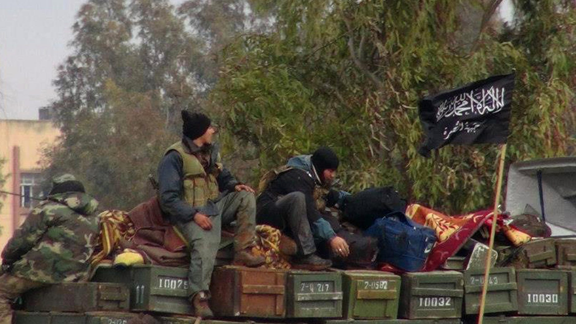 Rebels from Al-Qaeda affiliated Jabhat al Nusra, as they sit on a truck full of ammunition, at Taftanaz air base, that was captured by the rebels, in Idlib province, northern Syria. (AP Photo/Edlib News Network ENN, File)