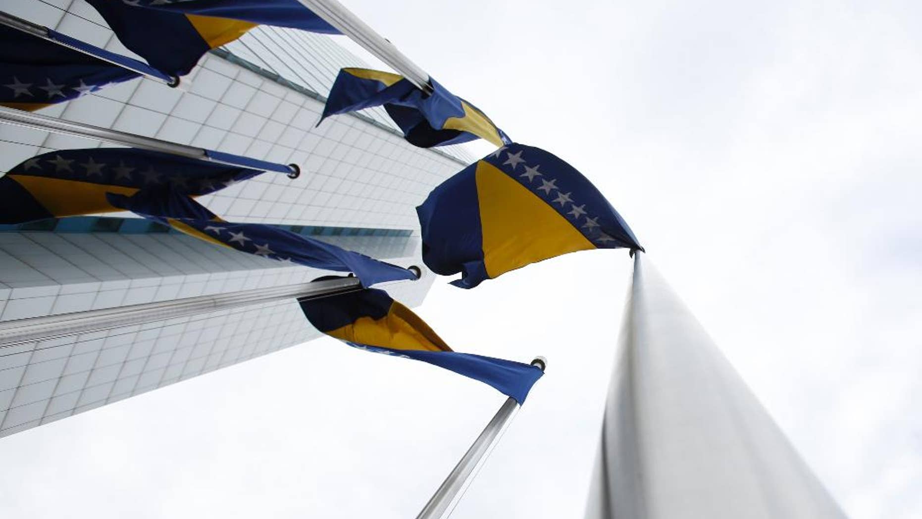 In this photo taken on Friday, Feb. 12, 2016 Bosnian flags flutter in the wind near government building in Sarajevo, Bosnia. The European Union said Tuesday, Sept. 20, 2016, it will examine whether Bosnia has what it takes to become a member as the bloc continues with plans to expand just months after Britain decided to leave. (AP Photo/Amel Emric)