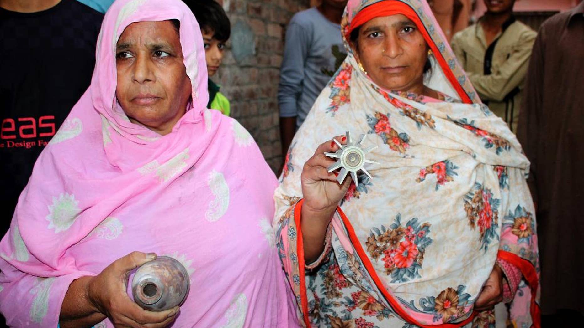 Pakistani villagers show remains of artillery allegedly fired by Indian forces at the border village of Chaprar situated on the Pakistan-Indian border, in Pakistan, Monday, Oct. 24, 2016. Pakistan and India say a cross-border exchange in the disputed region of Kashmir has caused fatalities, trading accusations over the latest shootings. Pakistan says "unprovoked" firing from the Indian side killed a villager and a year-and-a-half-old child. India said the shooting killed one of its soldiers and a 6-year-old boy. The shooting began overnight and continued into the morning hours. Both countries claim the territory of Kashmir in its entirety. (AP Photo/Shahid Ikram)