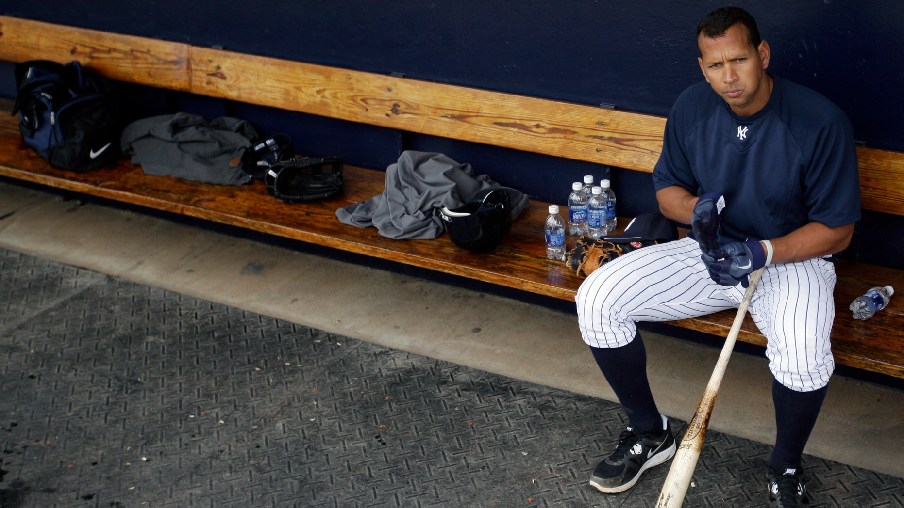 FILE - In this Feb. 25, 2012, file photo, New York Yankees' Alex Rodriguez sits in the dugout during practice at baseball spring training in Tampa, Fla. Baseball is threatening to kick Rodriguez out of the game for life unless the Yankees star agrees not to fight a lengthy suspension for his role in the sport's latest drug scandal, according to a person familiar with the discussions. The person spoke to The Associated Press on Wednesday, July 31, 2013, on condition of anonymity because no statements were authorized. (AP Photo/Matt Slocum, File)