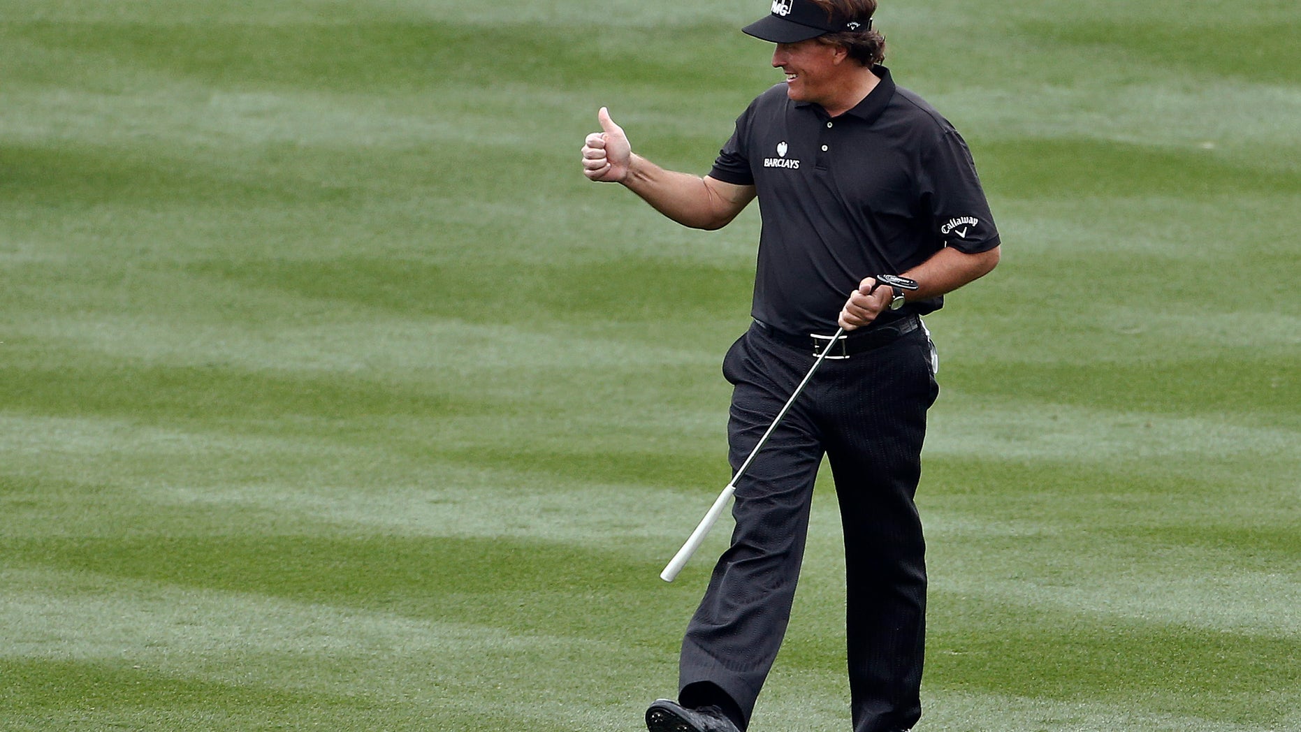 Phil Mickelson gives a thumbs-up to the cheering crowd as he walks up the 18th fairway during the final round of the Waste Management Phoenix Open golf tournament on Sunday, Feb. 3, 2013, in Scottsdale, Ariz. (AP Photo/Ross D. Franklin)