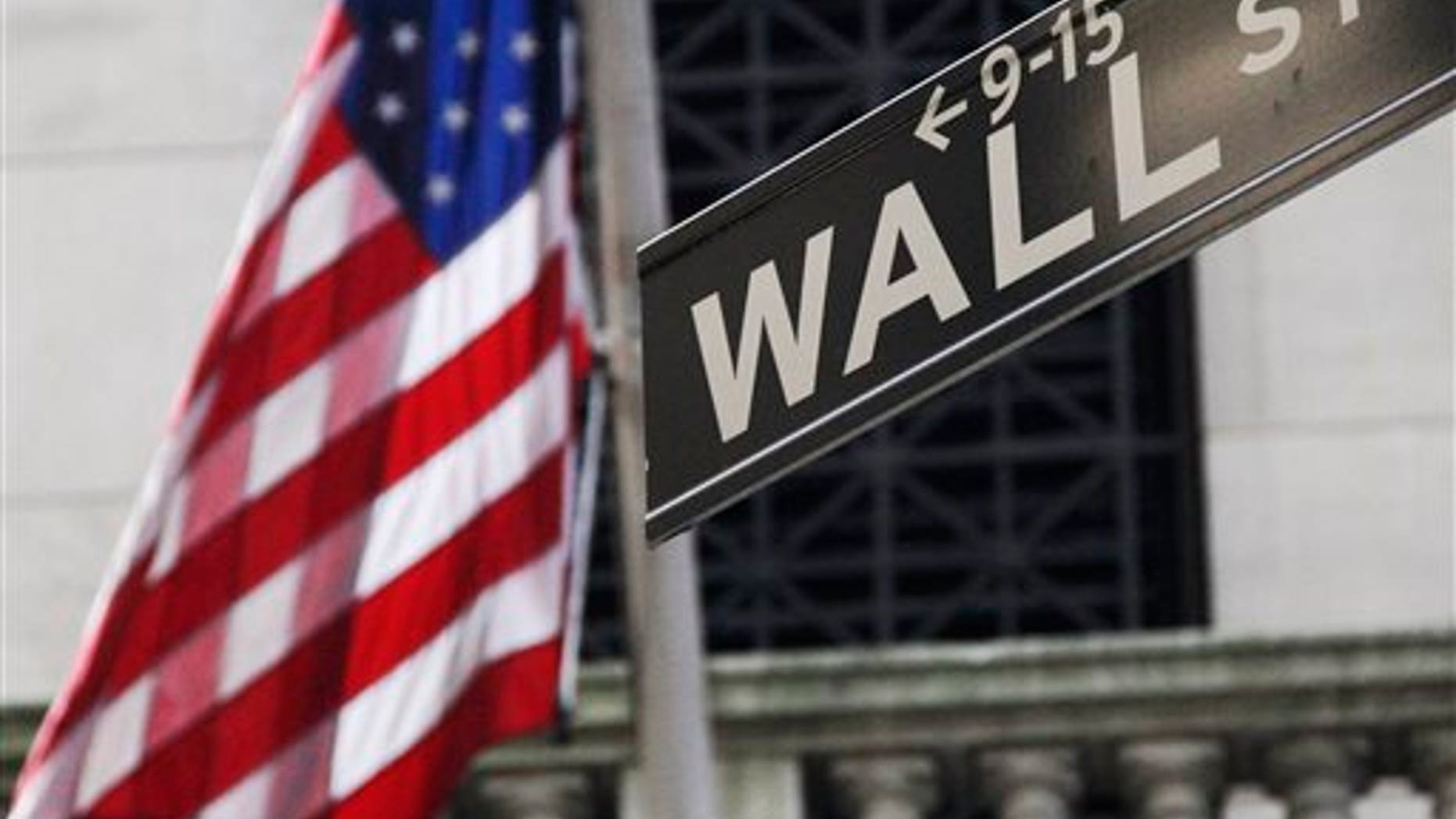 FILE - In this Monday, July 15, 2013, file photo, the American flag and a sign for Wall Street are shown outside the New York Stock Exchange. With Europe floundering, China facing slower growth and Japan struggling to sustain tentative gains, the U.S. job market is humming, and the pace of economic growth is steadily rising. Five full years after a devastating recession officially ended, the economy is finally showing the vigor that Americans have long awaited. (AP Photo/Mark Lennihan, File)