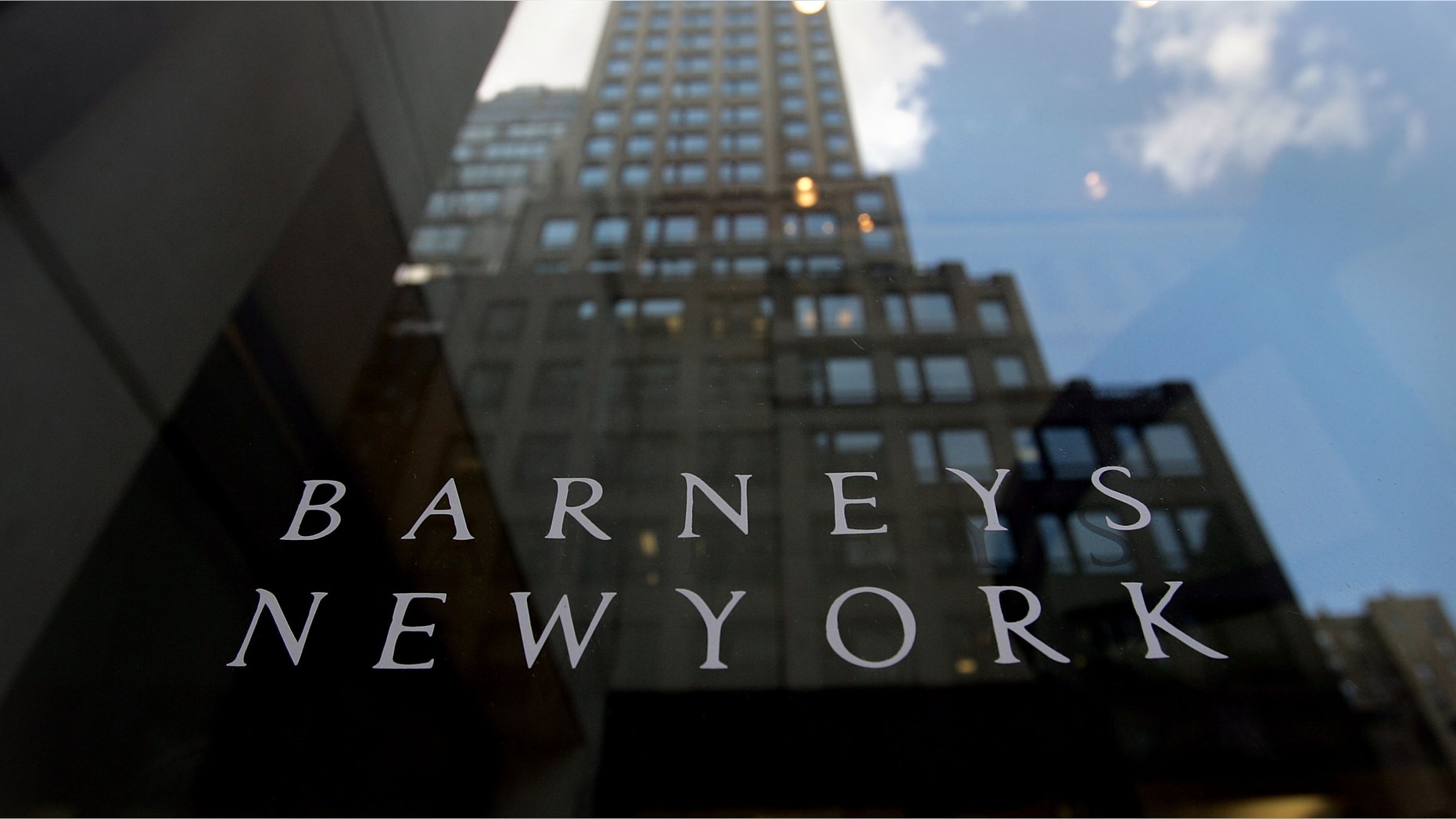 NEW YORK - JUNE 22: A building is reflected in the Barneys New York store window June 22, 2007 in New York City. Jones Apparel Group Inc. plans to sell Barneys New York to the Dubai investment firm Istithmar for $825 million. (Photo by Mario Tama/Getty Images)