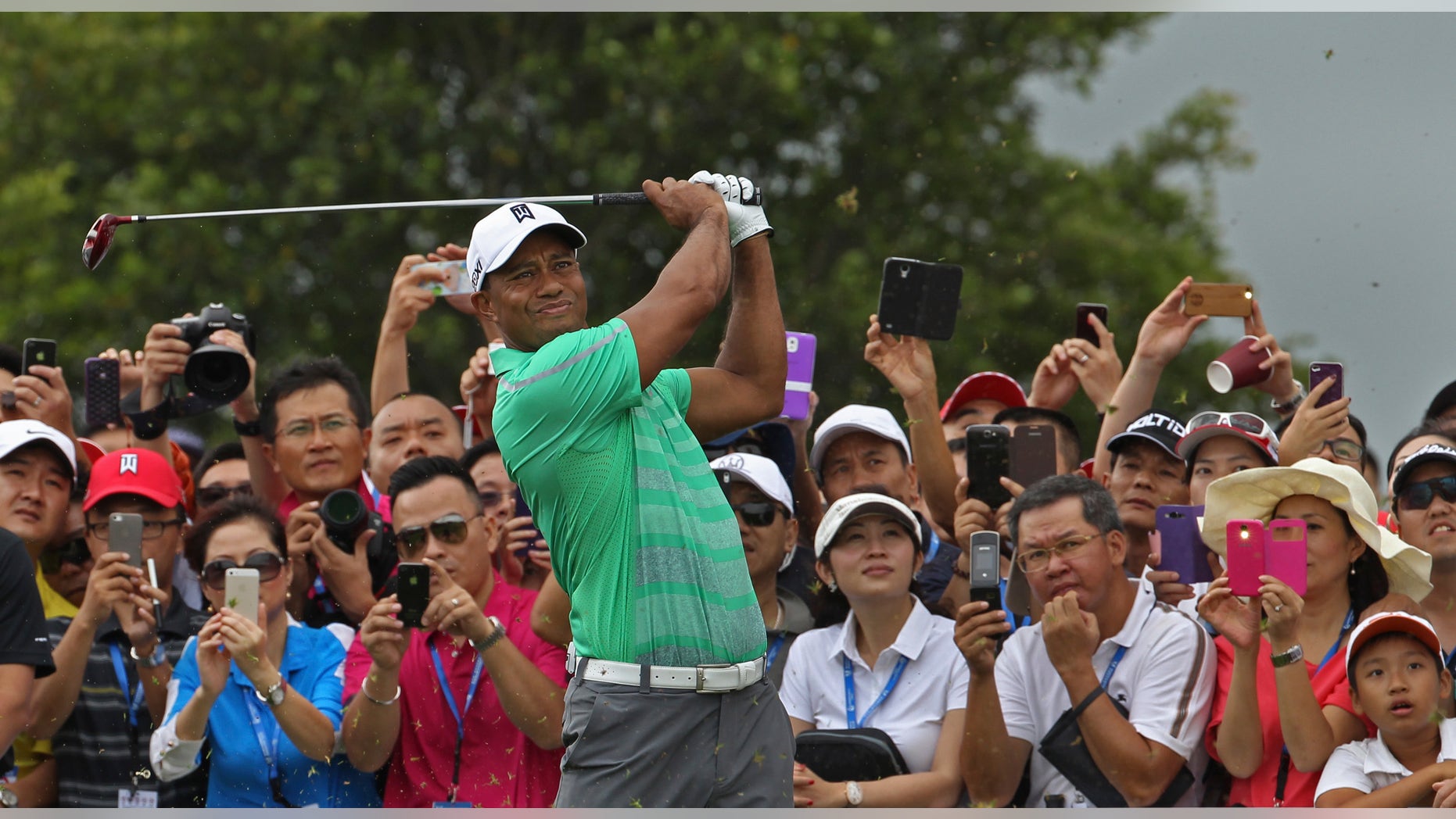 Tiger Woods of the United States tees off during an exhibition golf match against Rory Mcllory of Northern Ireland in Haikou, in southern China's island province Hainan, Monday, Oct. 28, 2013. (AP Photo/Vincent Yu)
