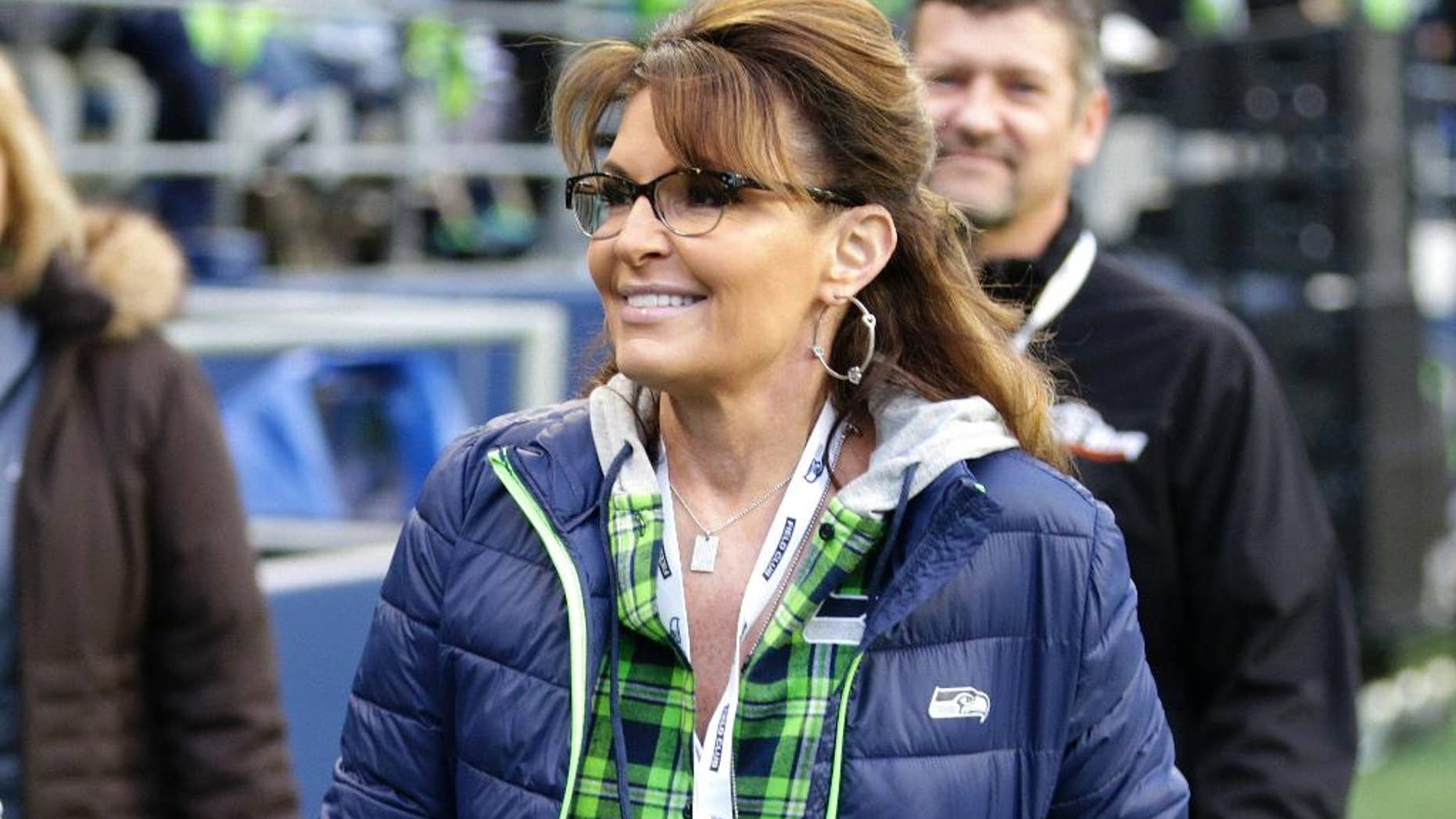 FILE - In a Thursday, Dec. 15, 2016 file photo, Sarah Palin, political commentator and former governor of Alaska, walks on the sideline before an NFL football game between the Seattle Seahawks and the Los Angeles Rams, in Seattle. A story posted by Newslo on Jan. 6, 2017, claiming Palin blamed recent fatal shooting at a Florida airport on “Mexican Muslims” is false. (AP Photo/Scott Eklund, File)