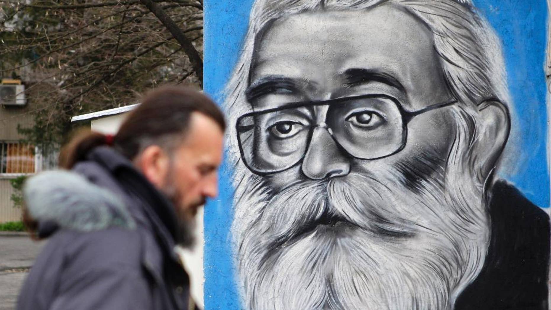 A man walks past a mural depicting Radovan Karadzic in Belgrade, Serbia, Thursday, March 24, 2016. A United Nations war crimes tribunal is passing judgment Thursday on former Bosnian Serb leader Radovan Karadzic, a landmark case against one of the alleged architects of Serb atrocities during Bosnia's 1992-95 war that left 100,000 dead. (AP Photo/Andrej Cukic)