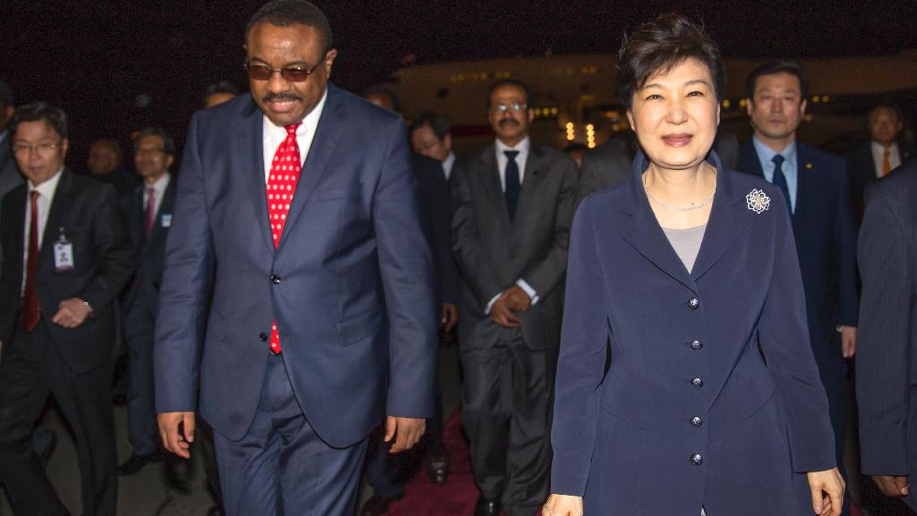 Ethiopia's Prime Minister Hailemariam Desalegn, left, walks with South Korea's President Park Geun-hye, right, as she arrives at the airport in Addis Ababa, Ethiopia, Wednesday, May 25, 2016. Geun-hye arrived in the Ethiopian capital on Wednesday evening at the start her three-nation visit to Africa, and is also slated to visit Kenya and Uganda to hold bilateral talks. (AP Photo/Mulugeta Ayene)