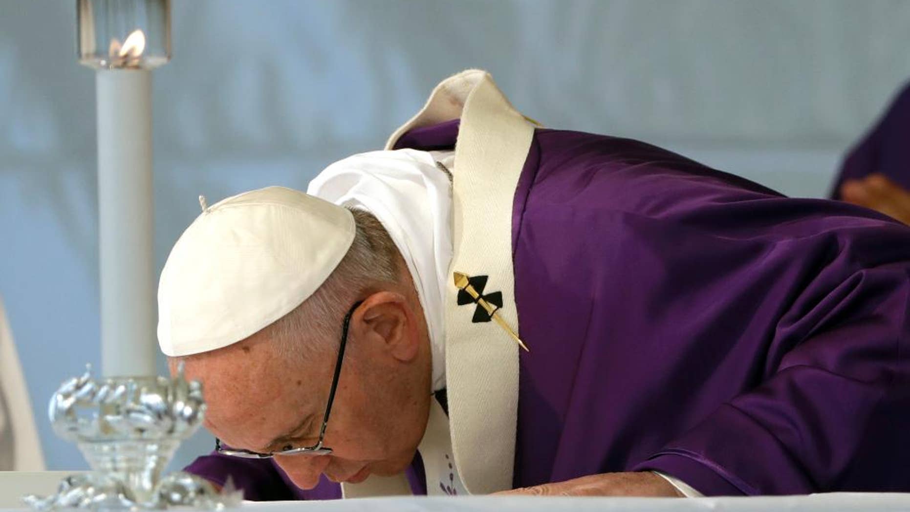 Pope Francis kisses the altar as he celebrates a Mass on the occasion of All Souls' Day, at the Prima Porta Cemetery in Rome, Wednesday, Nov. 2, 2016. (AP Photo/Gregorio Borgia)