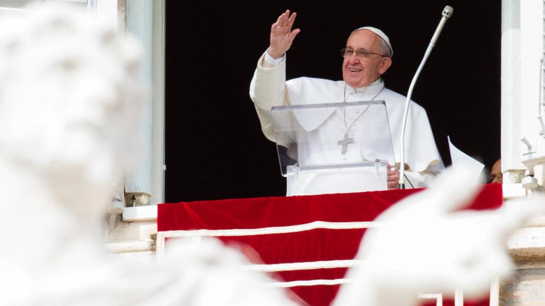 Pope Francis waves to faithful from his studio window overlooking St. Peter's Square, during the Angelus noon prayer at the Vatican, Sunday, Feb. 22, 2015. Francis told tens of thousands of Romans, tourists and pilgrims in St. Peter's Square that later Sunday he and top aides were starting a spiritual renewal retreat. Until Friday morning, they will spend time listening to reflections, meditating and praying in Ariccia, a Rome suburb. (AP Photo/Riccardo De Luca)