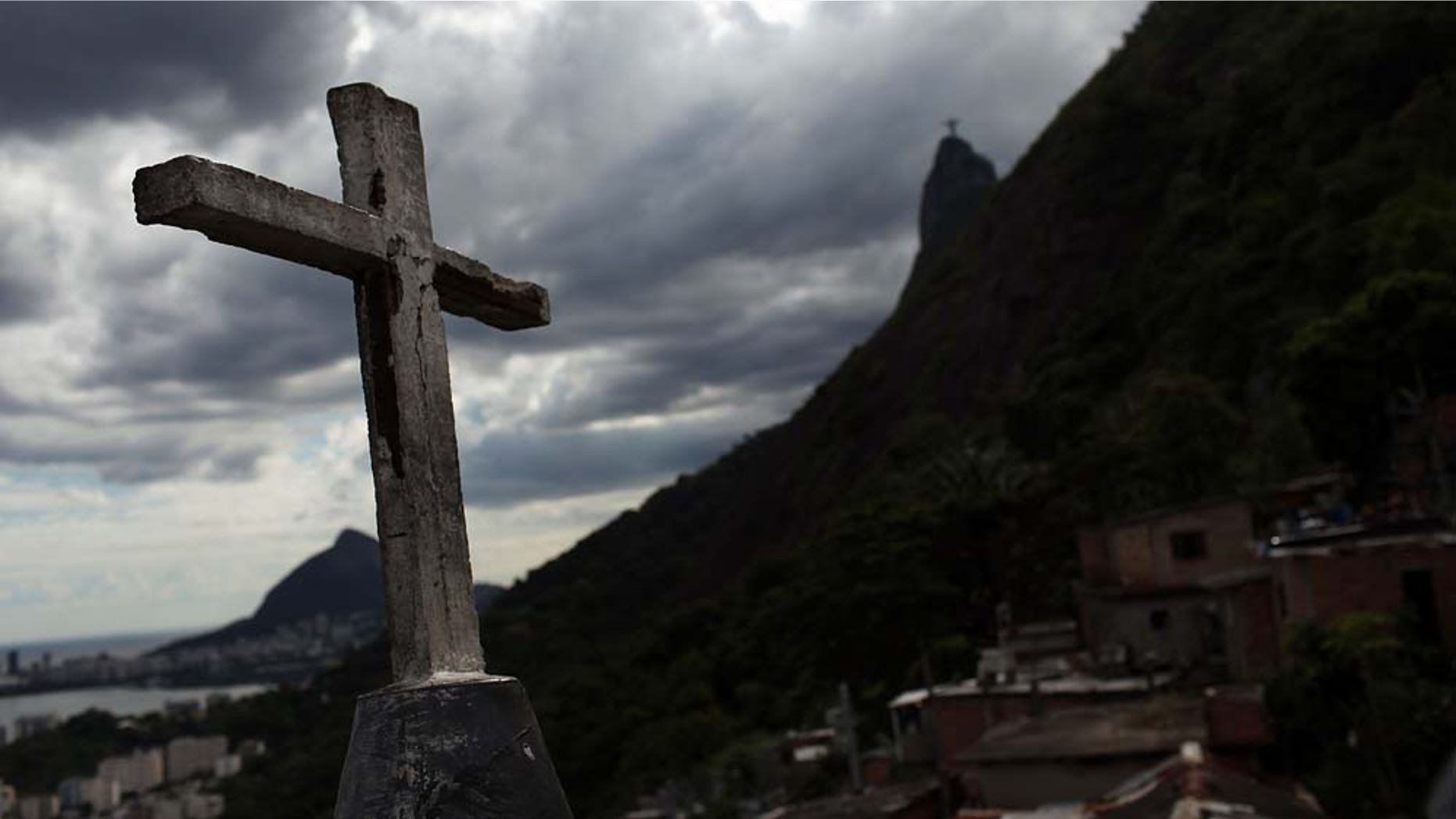 RIO DE JANEIRO, BRAZIL - DECEMBER 03: A church cross stands over recently "pacified" Santa Marta, one of Rio's oldest slums, or favela on December 3, 2009 in Rio de Janeiro, Brazil. Santa Marta is one of a number of Favelas in Rio where the police are attempting a softer touch by participating in community policing after they clear the area of drug gangs. It is believed that the police want to continue with these programs citywide ahead of the 2016 Olympic Games. As Brazil prepares to host the 2016 Summer Olympics international scrutiny is falling on Rio de Janeiro`s favelas where over 5,000 people were murdered last year alone. In the last week violence in tourist areas has increased as drug gangs are increasingly reacting to an increased police presence in the favelas. In figures released Tuesday by the IBGE (Instituto Brasileiro de Geografia e EstatÃstica) statistics agency it was found that an average of 68 young Brazilian men died violently each day between 1998 and 2008. These numbers included murder, traffic accidents and gang violence involving the police. (Photo by Spencer Platt/Getty Images)