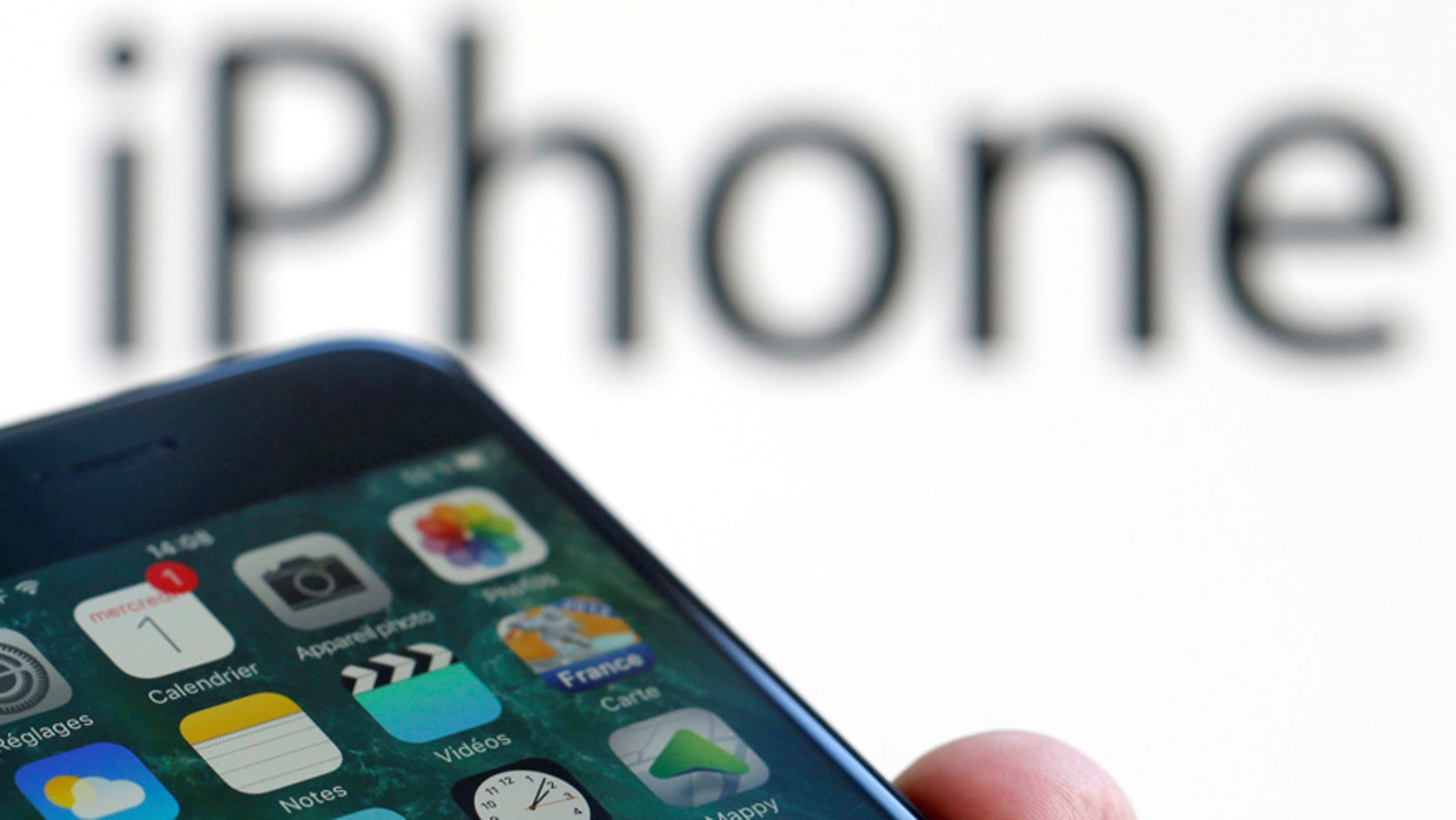 An Apple iPhone 7 and the company logo are seen in this illustration picture taken in Bordeaux, France, February 1, 2017. (REUTERS/Regis Duvignau)