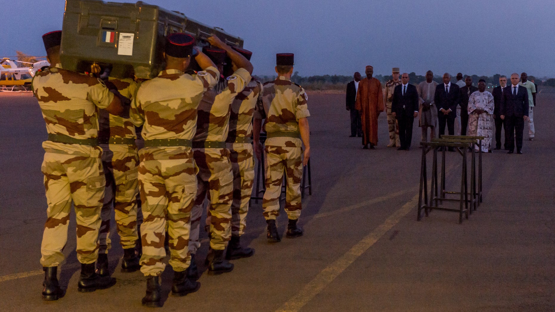 This photo taken and provided Sunday, Nov. 3, 2013, by the ECPAD or French army's image division, shows french soldiers carrying the casket of one of the two journalists executed in northern Mali, during a military ceremony of the removal of the bodies at Bamako military airport in Mali. The slayings of Ghislaine Dupont, 51, and Claude Verlon, 58, shocked France and underscored how insecure parts of northern Mali remain months after a French-led military intervention against al-Qaida and other extremists. (AP Photo/Gilles Gesquiere, ECPAD)