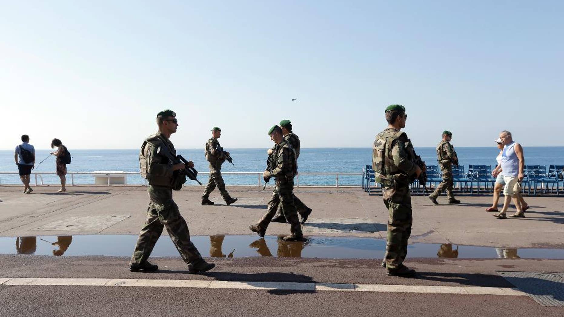 Soldiers patrol on the famed Promenade des Anglais in Nice, southern France, Tuesday, July 19, 2016. Joggers, cyclists and sun-seekers are back on Nice's famed Riviera coast, a further sign of normal life returning on the Promenade des Anglais where dozens were killed in last week's Bastille Day truck attack. (AP Photo/Claude Paris)