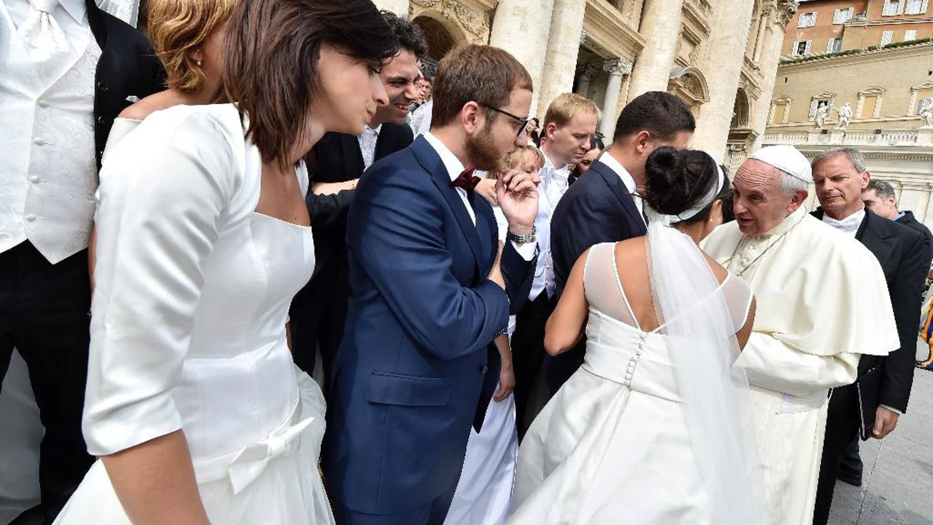 Pope Francis talks with a newlywed couple during his weekly general audience, in St. Peter's Square at the Vatican, Wednesday, Sept. 9, 2015. (L'Osservatore Romano/Pool Photo via AP)
