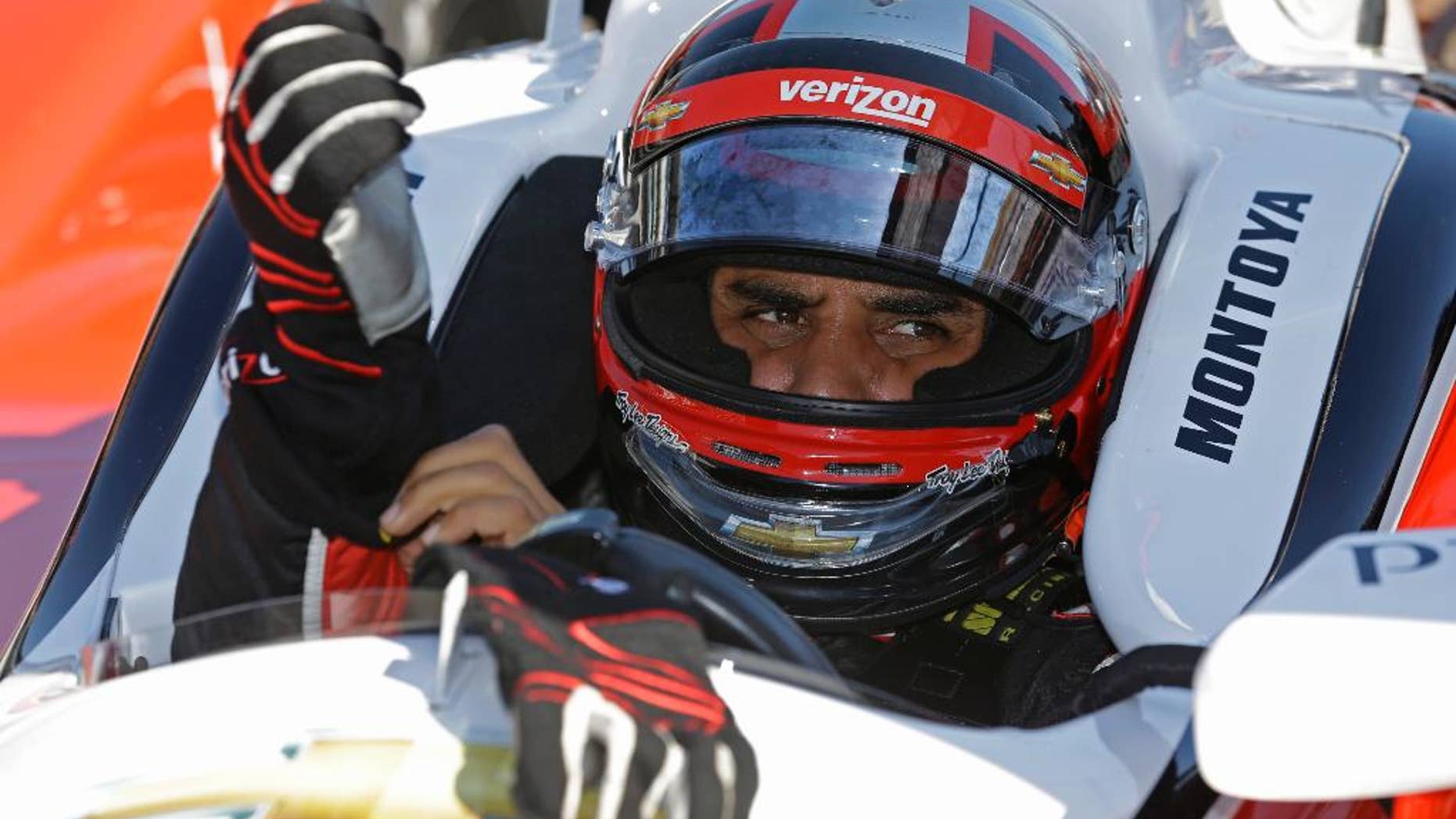 Juan Pablo Montoya, of Colombia, puts on his gloves as he prepares to drive on the final day of practice for the Indianapolis 500 IndyCar auto race at the Indianapolis Motor Speedway in Indianapolis, Friday, May 23, 2014. The 98th running of the Indianapolis 500 is Sunday. (AP Photo/Michael Conroy)