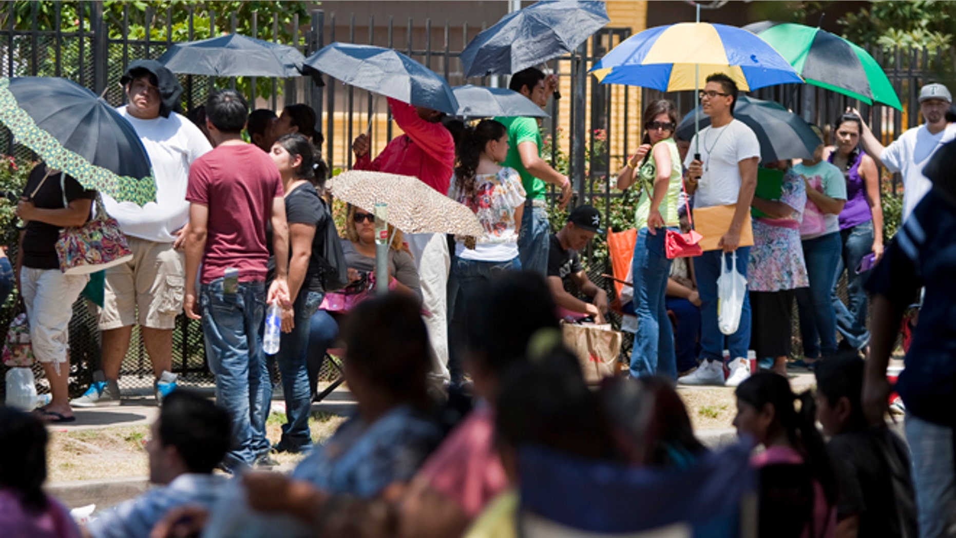 Illegal immigrants wait in line to get passports outside the Mexican Consulate in Houston in August, after the Department of Homeland Security began accepting applications to allow them to avoid deportation. (AP)