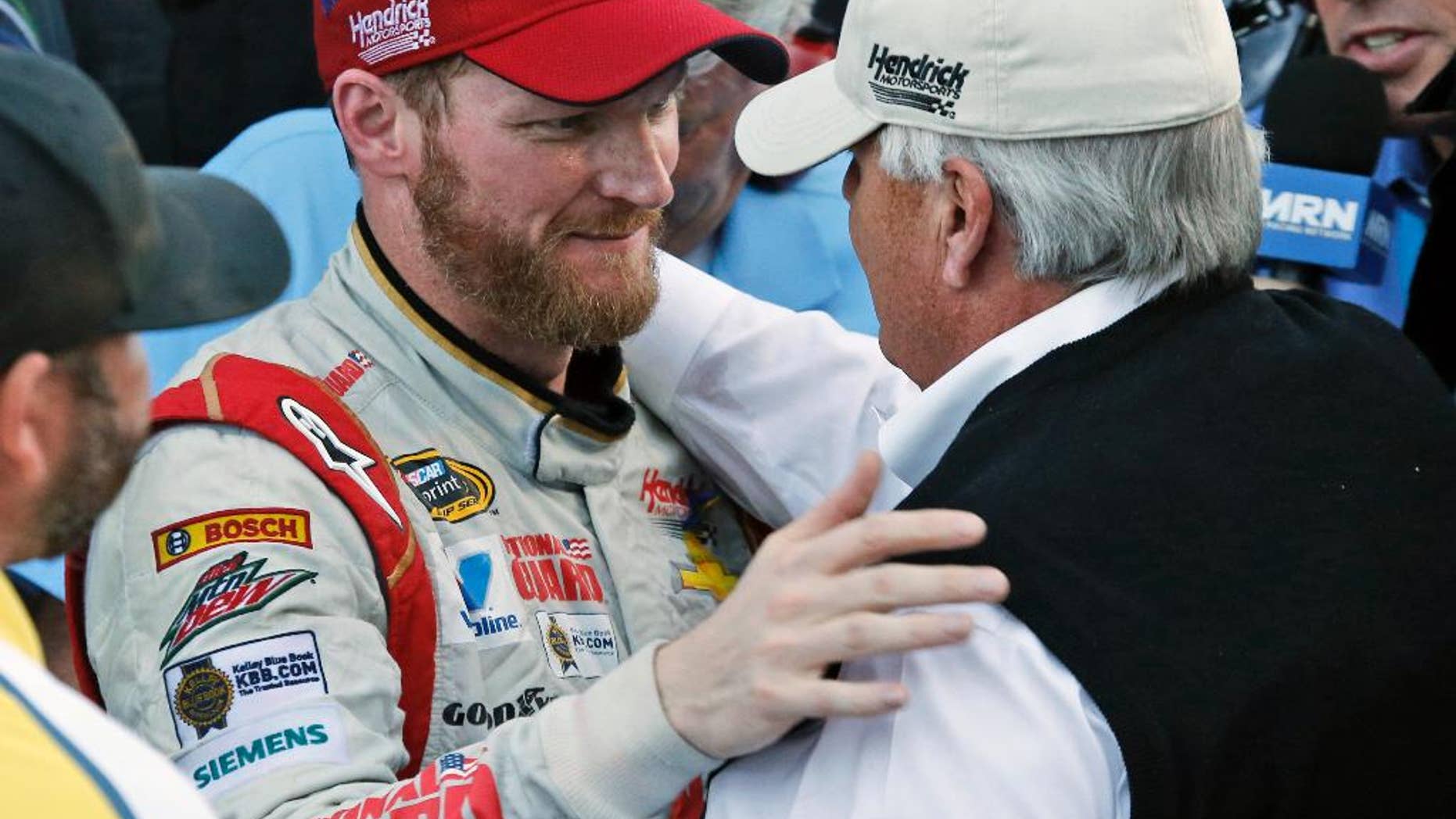 Dale Earnhardt Jr. celebrates winning the NASCAR Sprint Cup Series auto race with team owner Rick Hendrick, front right, in Victory Lane at Martinsville Speedway in Martinsville, Va., Sunday, Oct. 26, 2014. (AP Photo/Steve Helber)