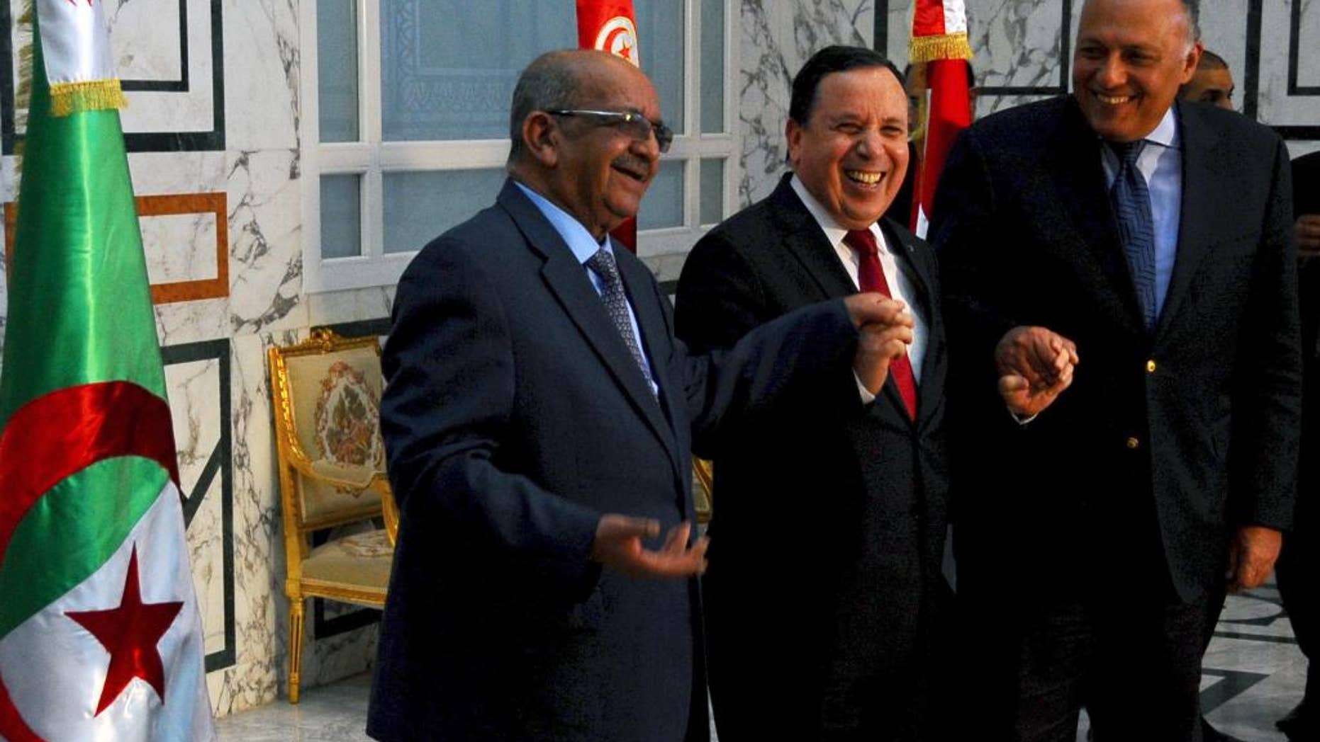 Tunisia Foreign Minister Khemaies Jhinaoui, center, shakes hands with his Egyptian counterpart Sameh Shoukry, right, and Algerian Minister of Maghreb Affairs, African Union and Arab League Abdelkader Messahel, prior to their meeting to discuss efforts to resolve the Libyan conflict in Tunis, Sunday, Feb. 19, 2017. (AP Photo/Hassene Dridi)