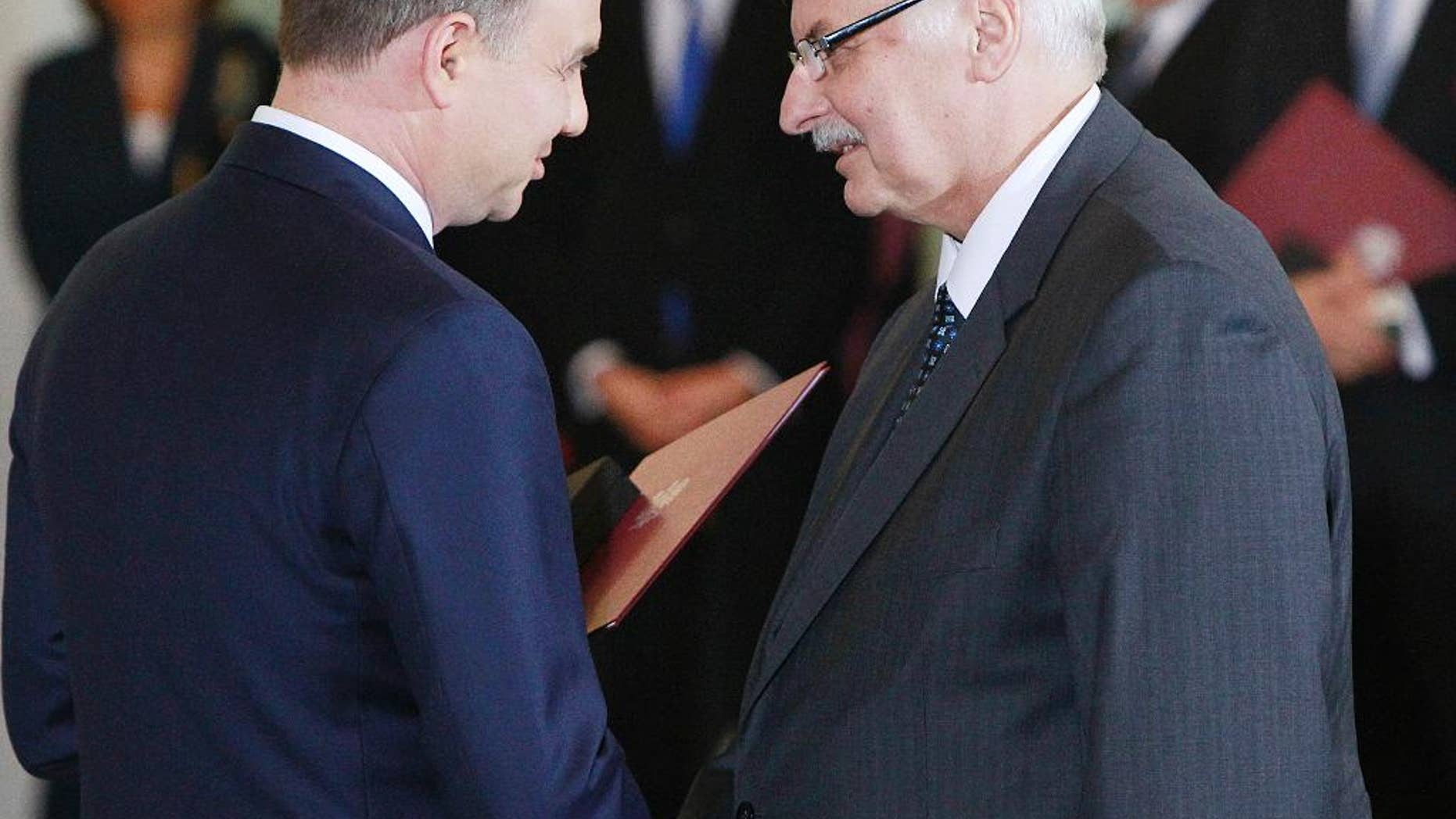 FILE - In this Nov.16, 2015 file photo Poland's President Andrzej Duda , left, congratulates Witold Waszczykowski as he is sworn in as new Polish Foreign Minister during the swearing-in ceremony of the new, conservative government at the Presidential Palace in Warsaw, Poland. Waszczykowski told The Associated Press he welcomes the new cooperation between Russia and the West in the fight against the Islamic State group, but insists that Ukraine's interests cannot be sacrificed as a reward to Moscow for those efforts. (AP Photo/Czarek Sokolowski)
