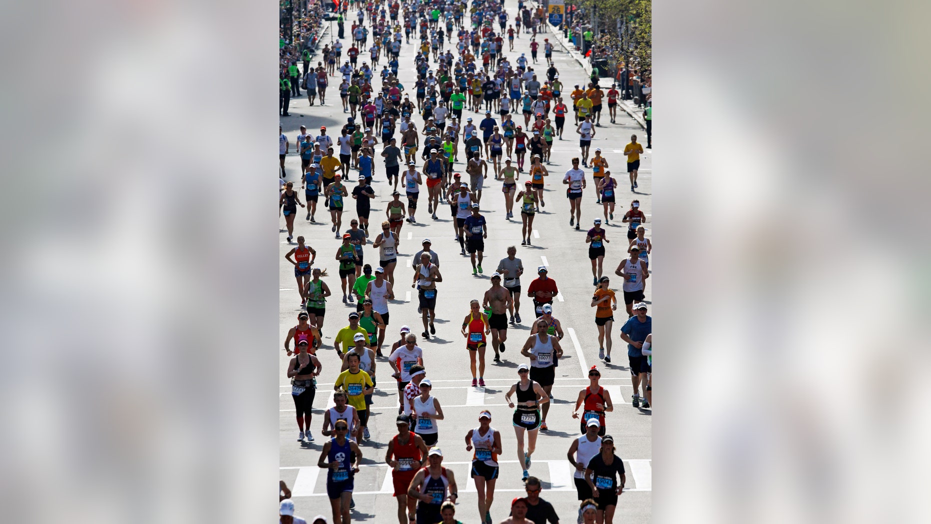 FILE - In this April 16, 2012, file photo, runners approach the finish line of the 116th Boston Marathon in Boston. About 2,300 people took race organizers up on a deal to skip the 2012 race and automatically qualify for the 2013 edition instead. Smart move. By re-starting their training and postponing their plans for a year, they are expected to be greeted with temperatures in the mid-50s on Monday, April 15, 2013, when the 117th edition of the Boston Marathon reaches Copley Square. (AP Photo/Charles Krupa, File)