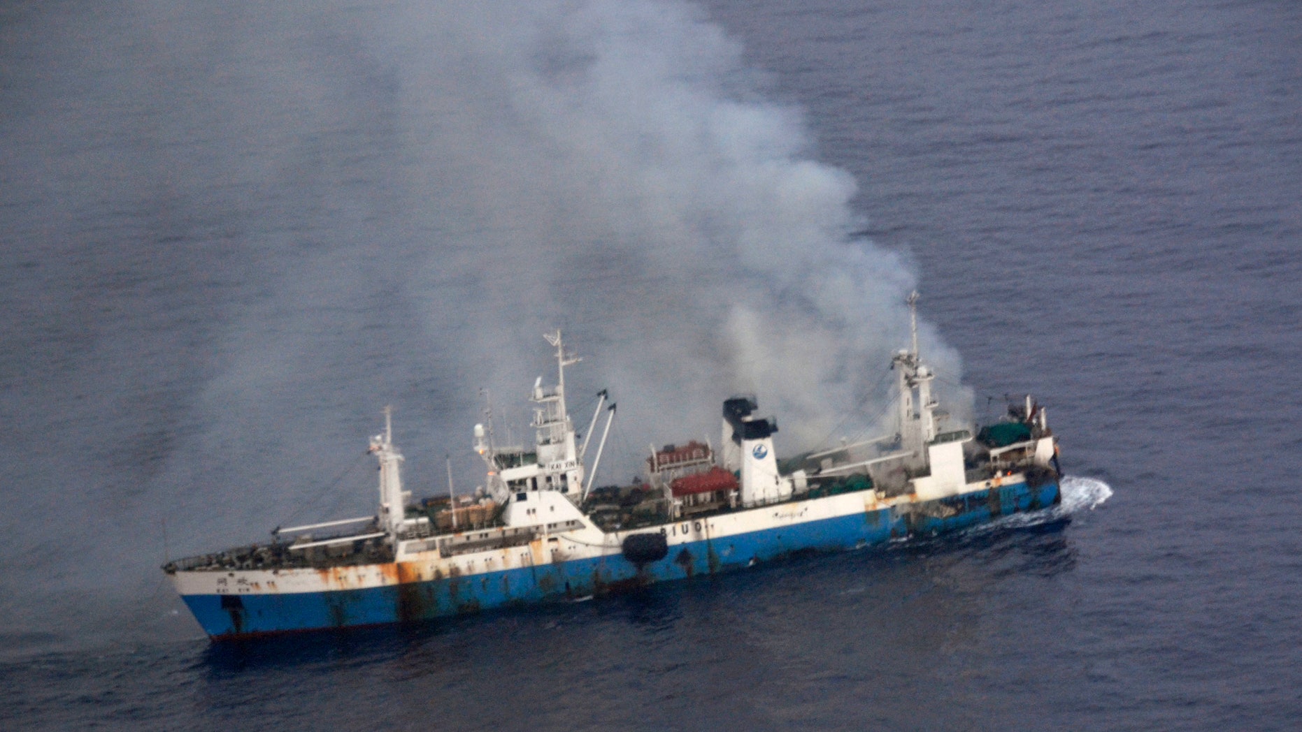 In this picture released by Chile's Air Force, smoke billows from a Chinese factory fishing ship Kai Xin just off the coast of Antarctica, Wednesday, April 17, 2013. Chilean authorities say around 90 crew members have been rescued from the burning ship by the crew of the Norwegian ship Juvel, and Chile’s military says it’s ready to intervene if necessary to prevent an ecological disaster. (AP Photo/Chile's Air Force)