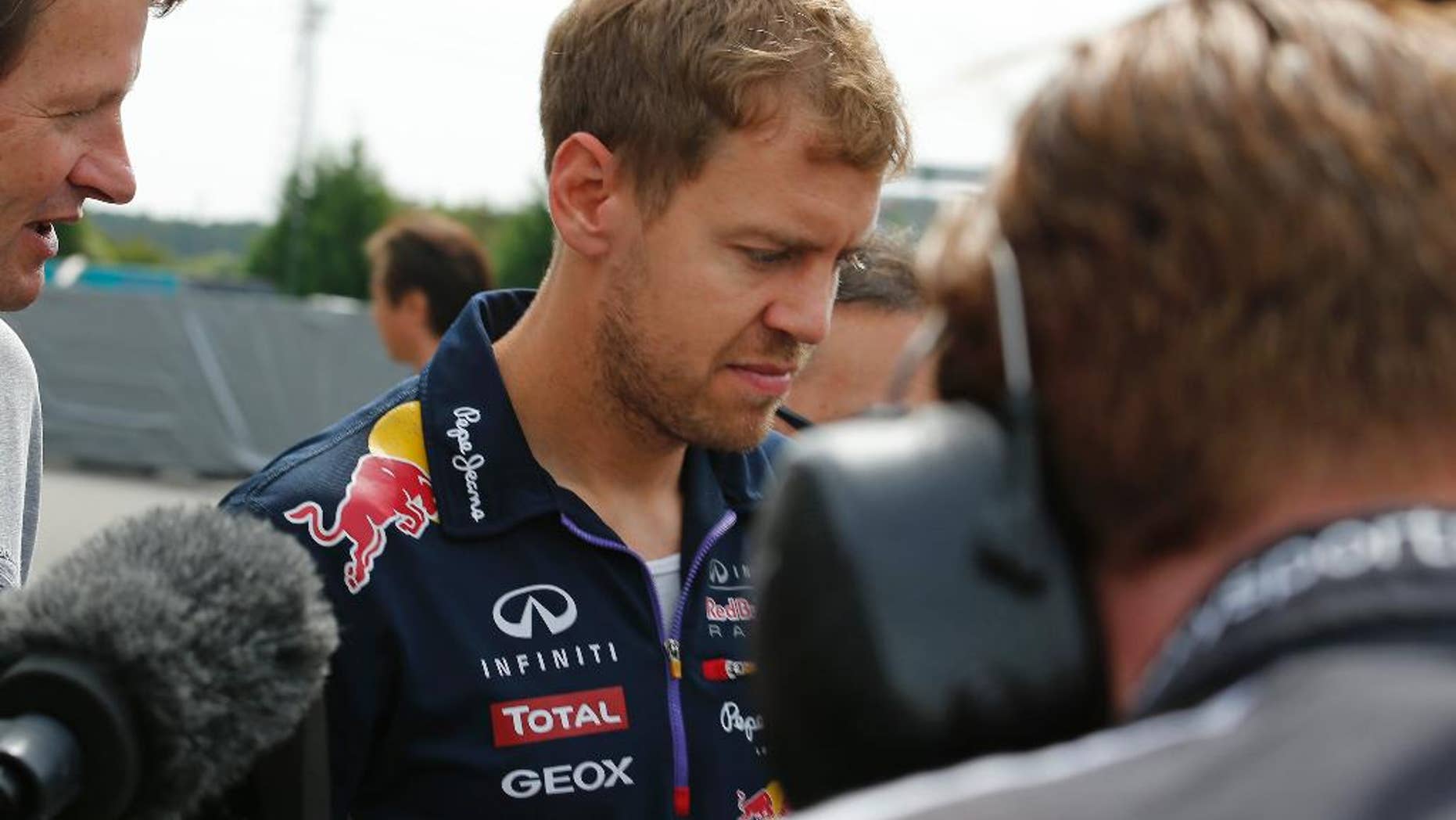 Red Bull Racing driver Sebastian Vettel of Germany is surrounded by the media at the paddock before the third practice session for Sunday's Japanese Formula One Grand Prix at the Suzuka Circuit in Suzuka, central Japan, Saturday, Oct. 4, 2014. Four-time defending champion Vettel will leave Red Bull at the end of the season, with the team expecting him to join Ferrari. (AP Photo/Shuji Kajiyama)