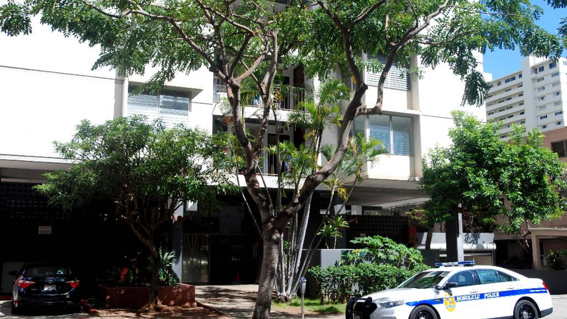 A police car sits outside an apartment building where human remains were found in Honolulu's Waikiki neighborhood, Wednesday, April 12, 2017. Police arrested a 26-year-old man Tuesday on suspicion of second-degree murder after human remains were found in his Waikiki apartment. (AP Photo/Jennifer Sinco Kelleher)