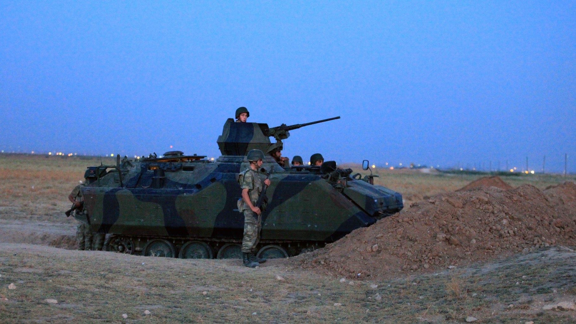 Turkish military stand near the Turkey-Syria border in Akcakale, Turkey, early Friday, Oct. 5, 2012. Turkey fired on Syrian targets for a second day Thursday, but said it has no intention of declaring war, despite tensions after deadly shelling from Syria killed five civilians in a Turkish border town. (AP Photo)