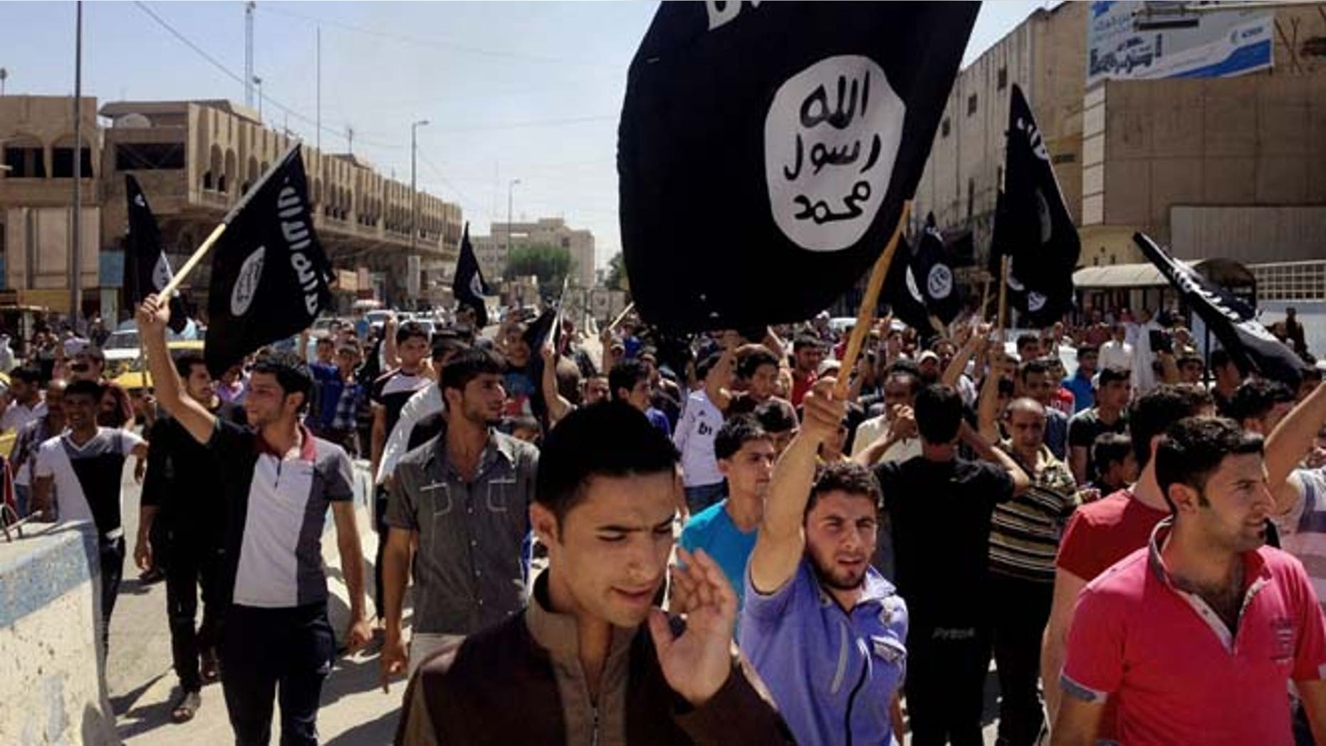 June 16, 2014: Demonstrators chant pro-Islamic State group slogans as they carry the group's flags in front of the provincial government headquarters in Mosul, 225 miles northwest of Baghdad.