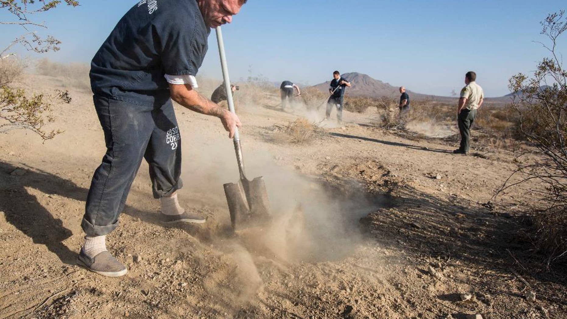 FILE - In this Nov. 15, 2013 file photo, workers fill the two shallow graves at the site on the outskirts of Victorville that contained the skeletal remains of members of missing McStay family in San Bernardino, Calif. Police investigating a missing persons report found a tall lamp lying on a bedroom floor and open suitcases containing folded clothes in the walk-in closet of a California home, according to court records unsealed Friday, Jan. 23, 2015, in the investigation that eventually led to the discovery of four dead family members in shallow desert graves. The documents offer the most detailed look yet of the disheveled condition of the family’s house in Fallbrook, Calif., when investigators arrived in February 2010 while searching for Joseph McStay, then 40, his wife Summer, 43, and their two sons, Gianni, 4, and Joseph Jr., 3.(AP Photo/Ringo H.W. Chiu, File)