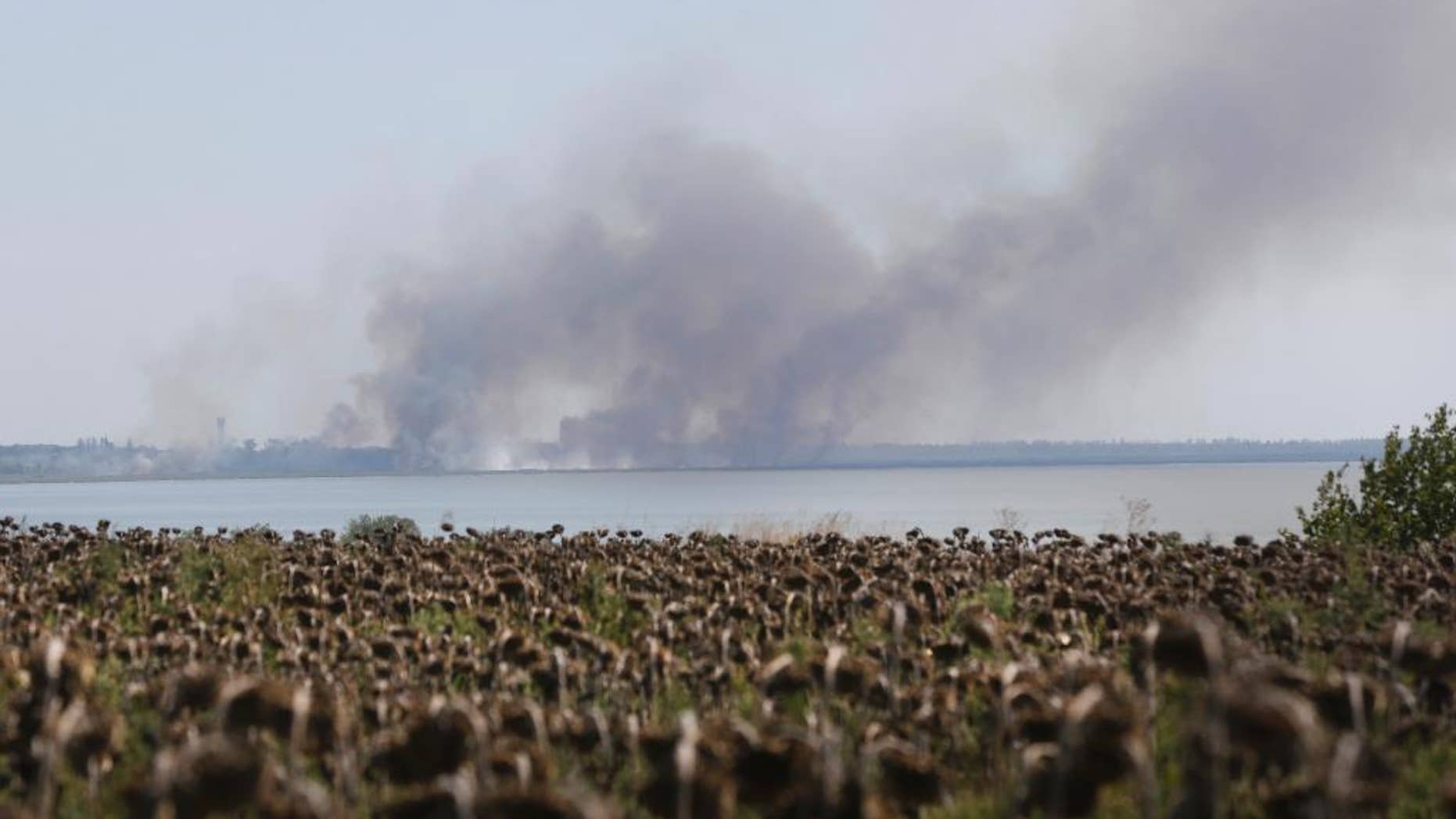 Aug. 26, 2014: Smoke rises after shelling in the town of Novoazovsk, eastern Ukraine. Towering columns of smoke rose Tuesday from outside a city in Ukraine's far southeast after what residents said was a heavy artillery barrage.