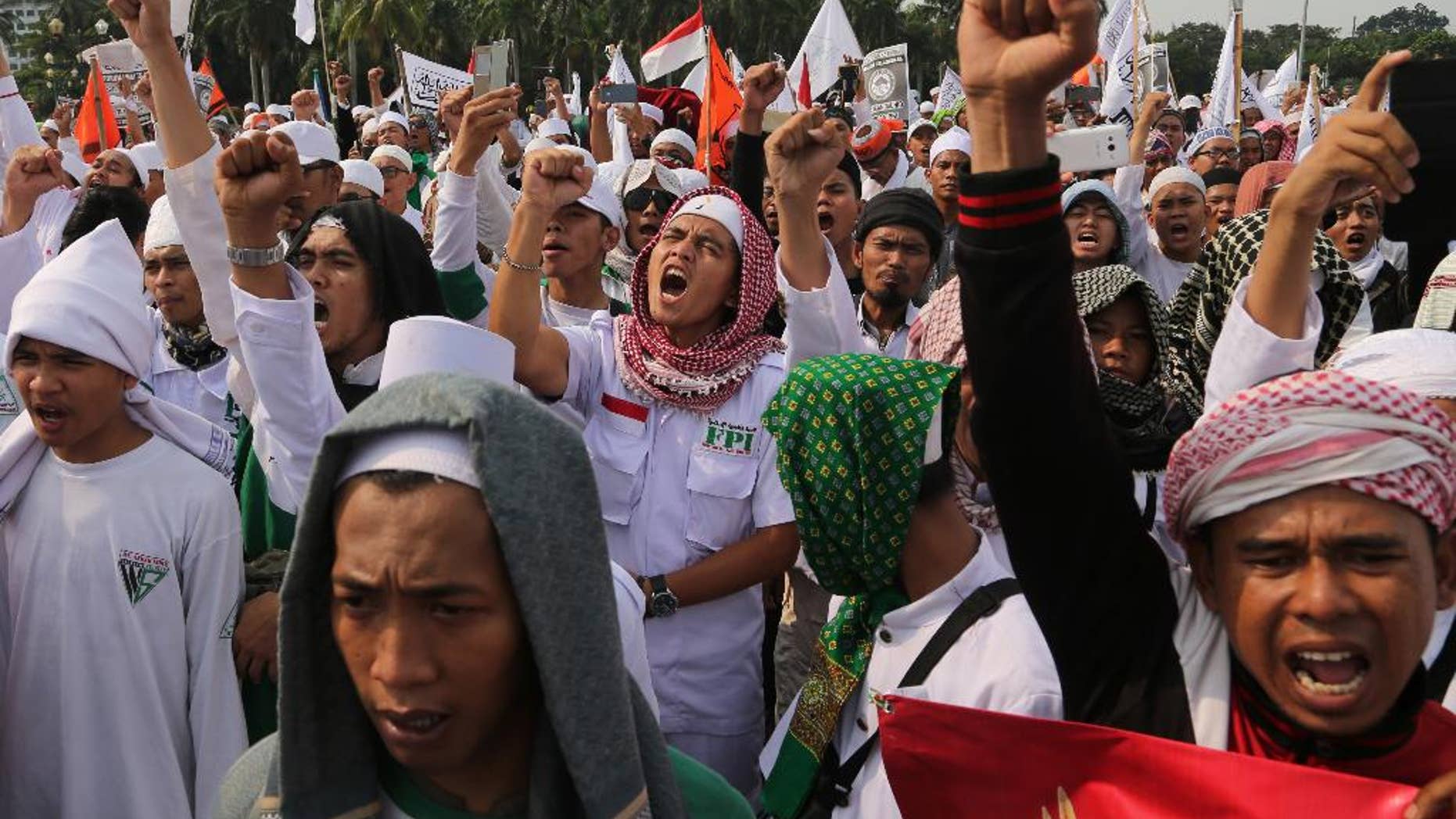 Muslim men shout slogans during a rally against communism outside the presidential palace in Jakarta, Indonesia, Friday, June 3, 2016. About a thousand members of hard-line Islamic groups marched Friday in the capital to denounce a government plan for an investigation into anti-communist massacres in 1965, saying it will help revive communism in the world's largest Muslim nation. (AP Photo/Tatan Syuflana)