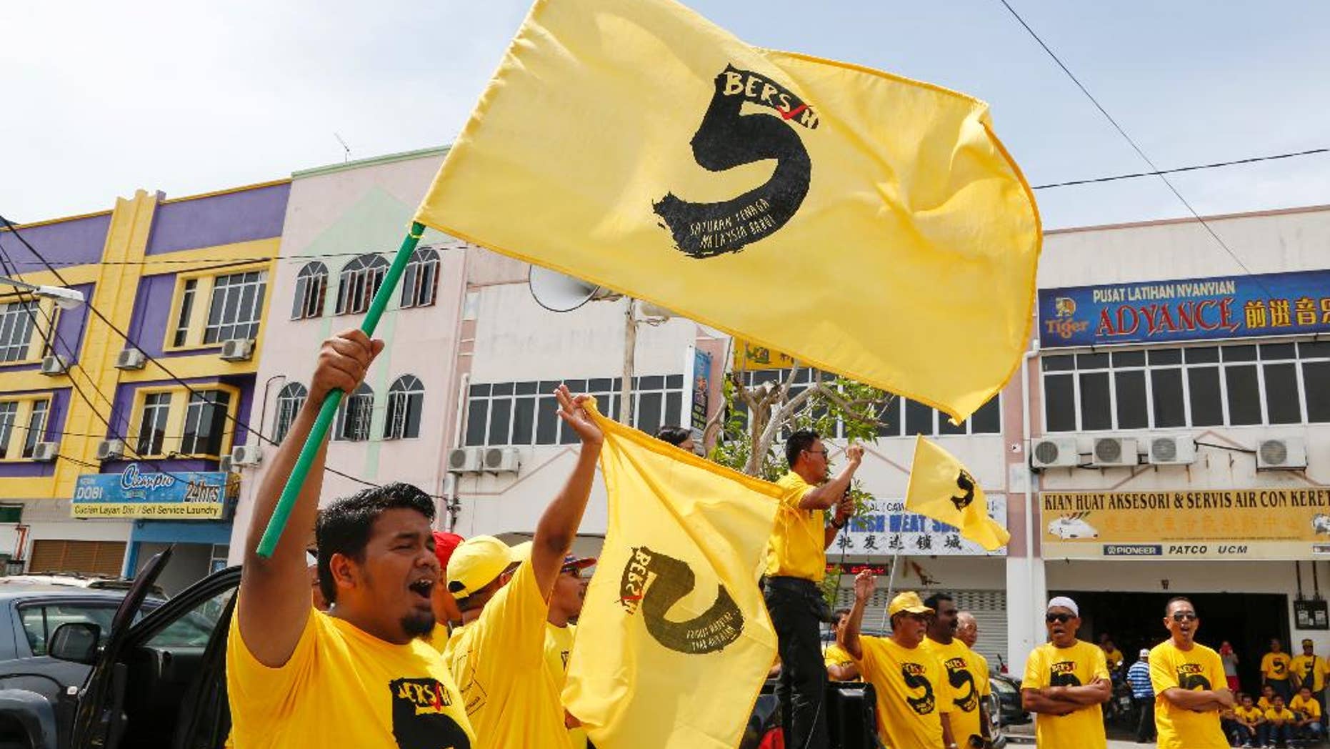 In this Oct. 15, 2016 photo, pro-democracy activists wave "Bersih 5" flags in Sekinchan, Malaysia. Malaysian pro-democracy activists have vowed to go ahead with a massive rally on Saturday, Nov. 19 to demand Prime Minister Najib Razak's resignation over a financial scandal despite a police ban and fears of clashes with a pro-government group. Chairwoman Maria Chin of Bersih says Saturday's rally in downtown Kuala Lumpur will protest poor governance and a lack of accountability that have led to "grand corruption" in the 1MDB fund. (AP Photo/Lim Huey Teng)