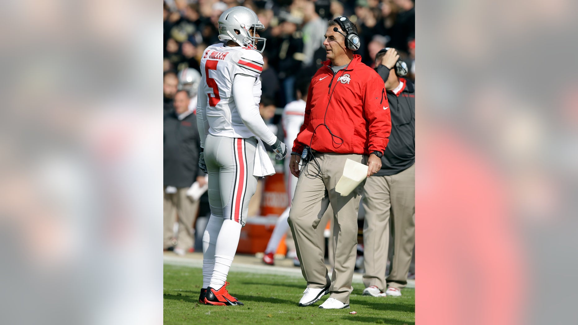 Ohio State quarterback Braxton Miller, left, talks with head coach Urban Meyer during the first half of an NCAA college football game against Purdue in West Lafayette, Ind., Saturday, Nov. 2, 2013. (AP Photo/Michael Conroy)