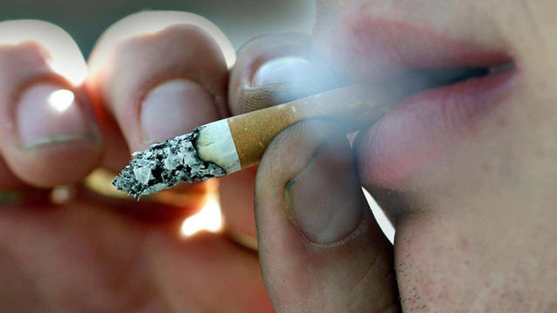 A person smokes outside his place of work in Belfast, Northern Ireland, Monday, April, 30, 2007. A smoking ban in all public places has come into effect from Monday in Northern Ireland. (AP Photo/Peter Morrison)
