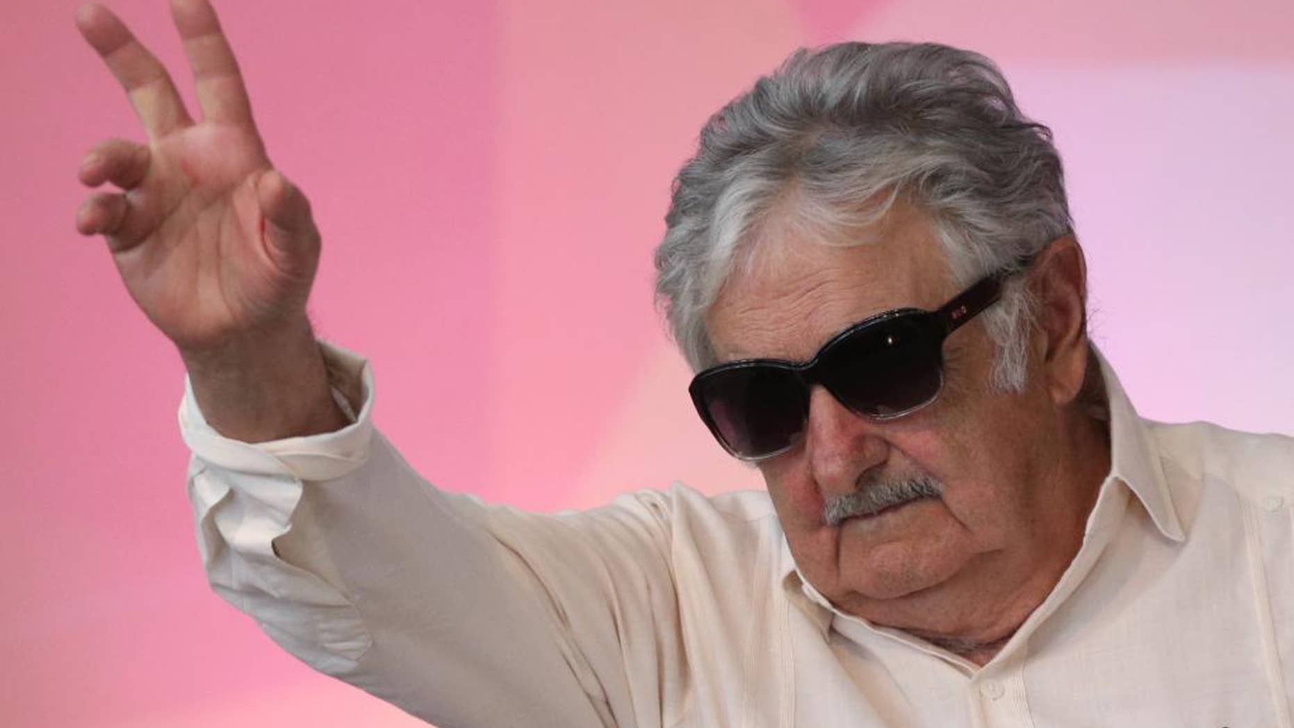 FILE - In this Dec. 16, 2015 file photo, Uruguay's former President Jose Mujica waves to the crowd during the opening of the National Youth Conference, in Brasilia, Brazil. Mujica says Venezuelan President Nicolas Maduro is “crazy as a goat,” while speaking Wednesday, May 18, 2016, at a press conference where he was asked about an escalating row between Maduro and the head of the Organization of American States. (AP Photo/Eraldo Peres, File)