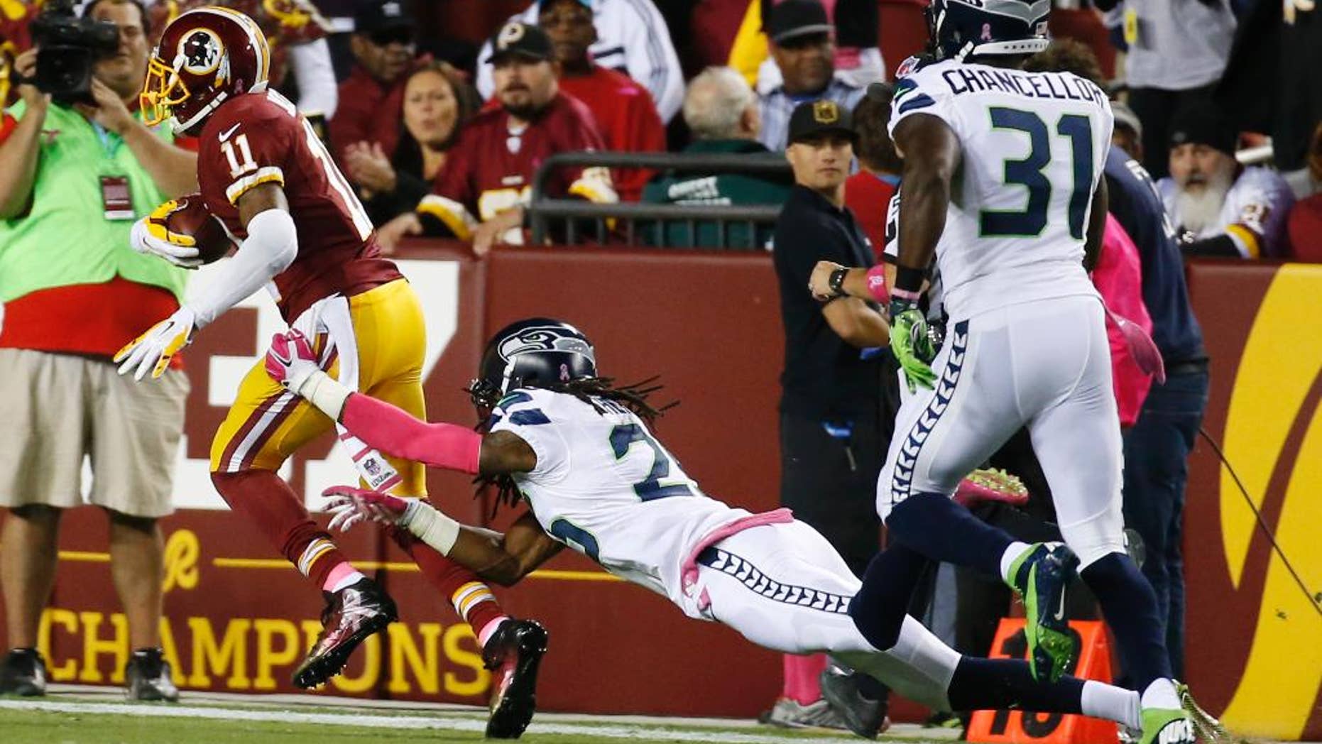 Seattle Seahawks cornerback Richard Sherman (25) misses the tackle as Washington Redskins wide receiver DeSean Jackson (11) runs for a touchdown during the first half of an NFL football game in Landover, Md., Monday, Oct. 6, 2014. (AP Photo/Alex Brandon)