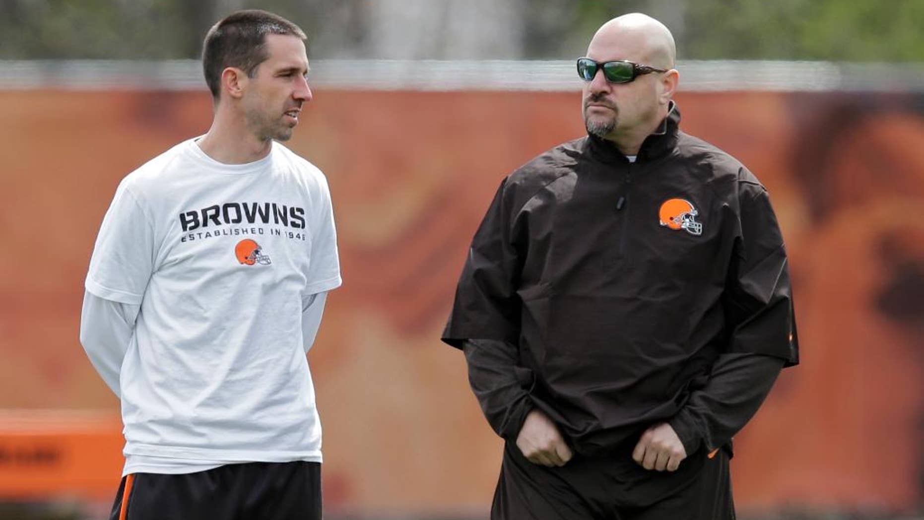 Cleveland Browns offensive coordinator Kyle Shanahan, left, talks with head coach Mike Pettine during a voluntary minicamp workout at the NFL football team's facility in Berea, Ohio Thursday, May 1, 2014. (AP Photo/Mark Duncan)